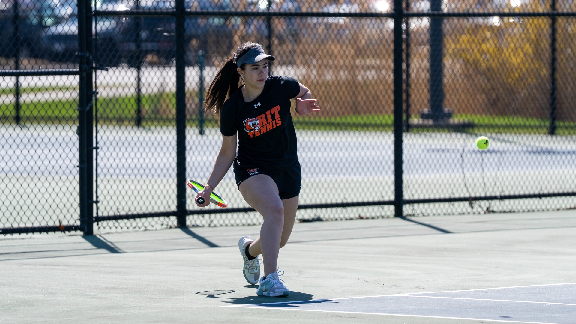 A women's tennis player returns a serve