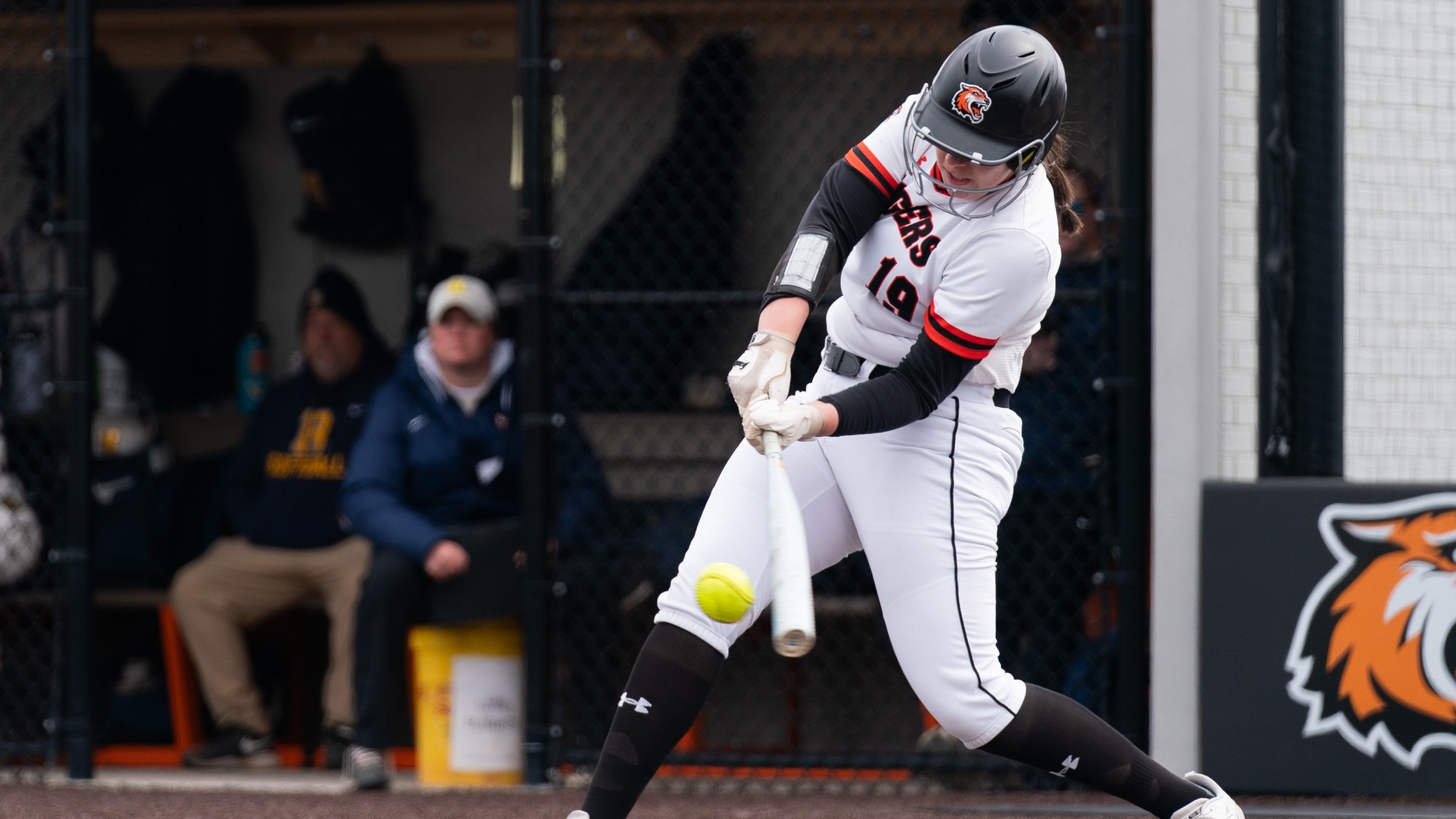 a softball player hitting a ball 