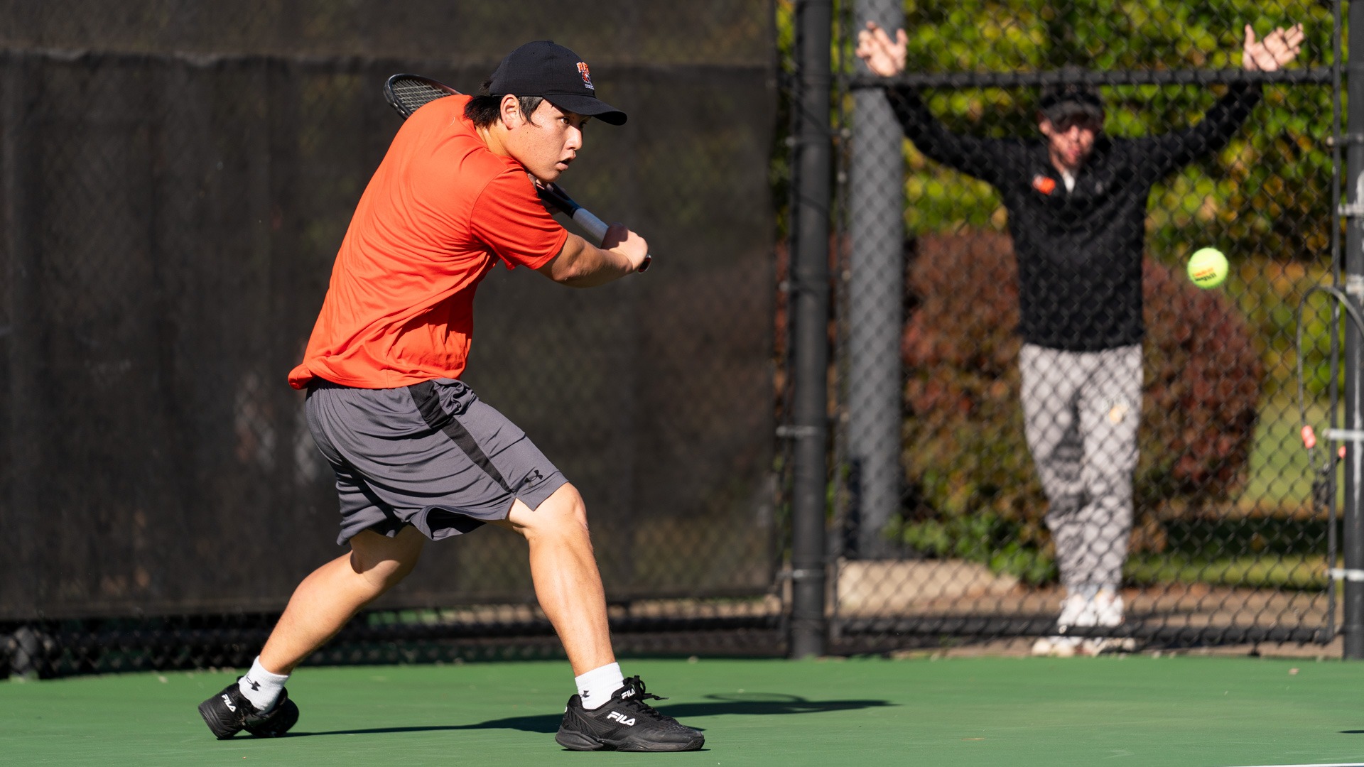A men's tennis player hits a forehand in a match