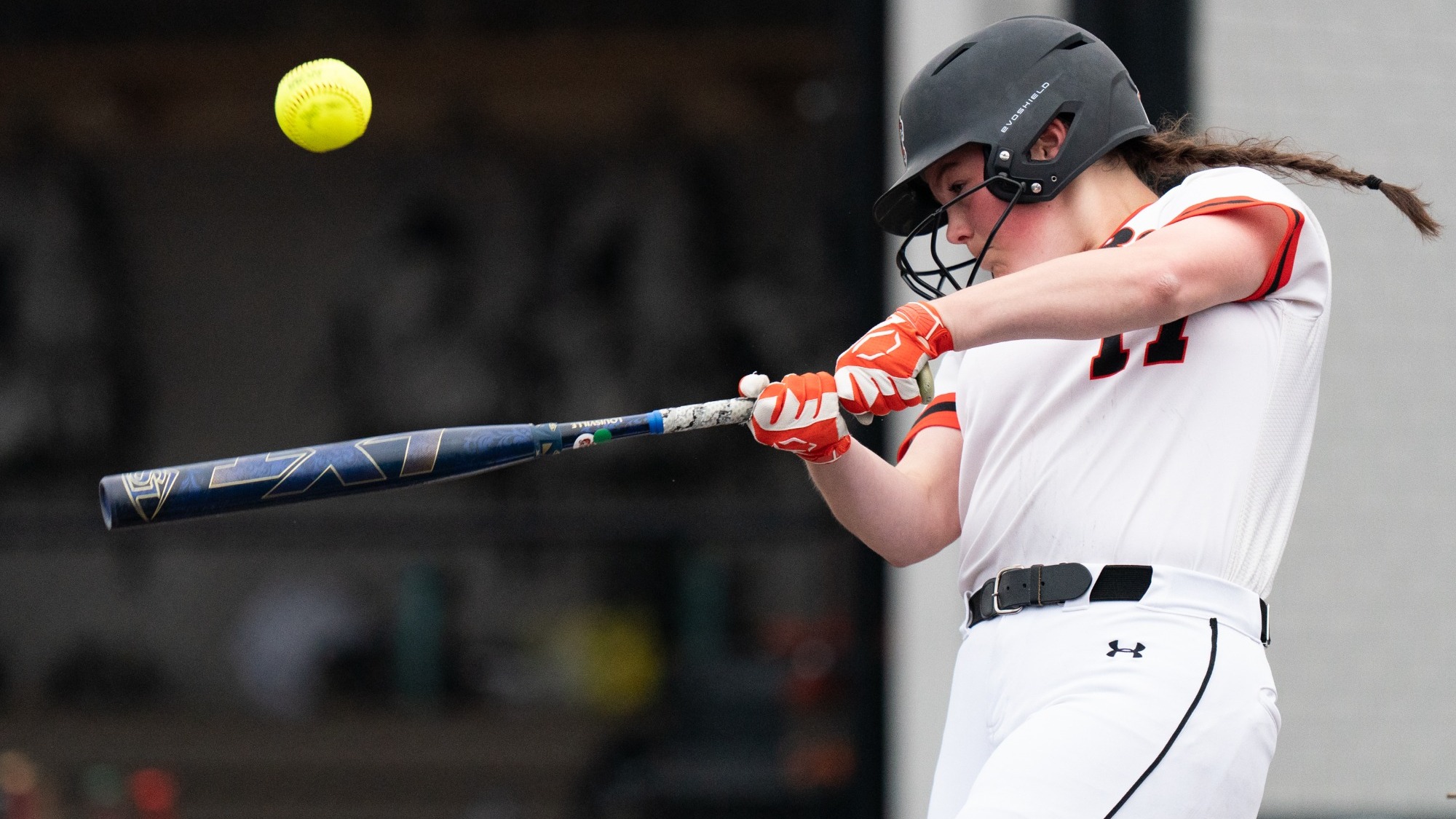 a softball player hitting a ball