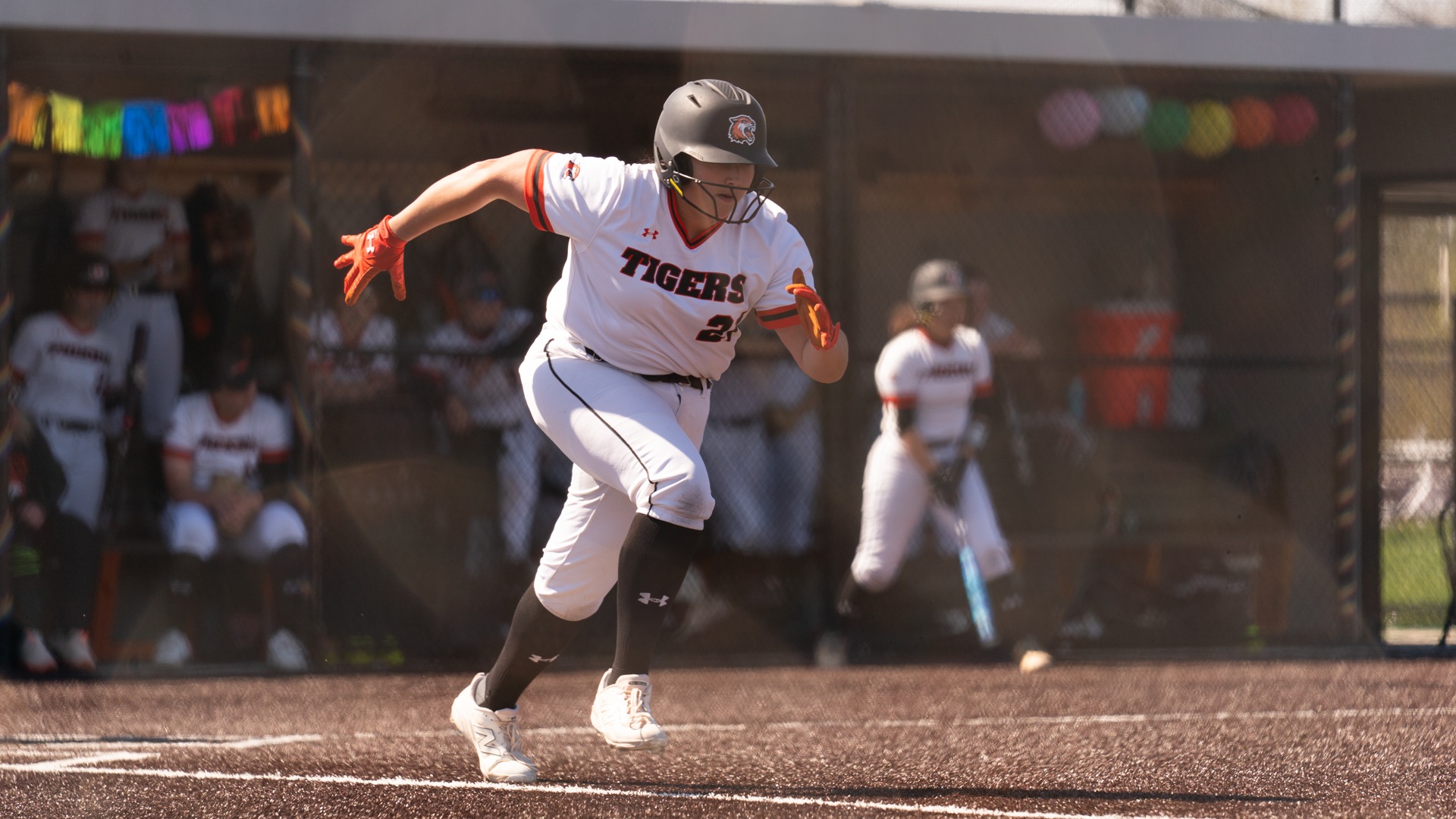a softball player running to first out of the batters box