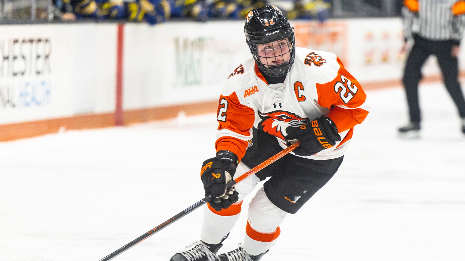 An action photo of Emma Pickering skating with puck