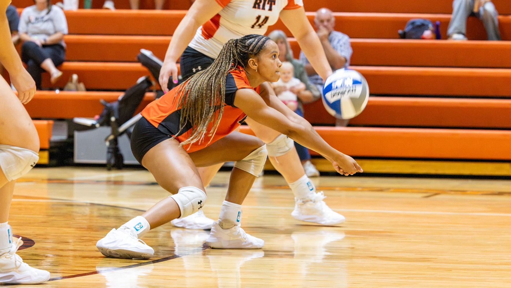 a women's volleyball player digging a ball
