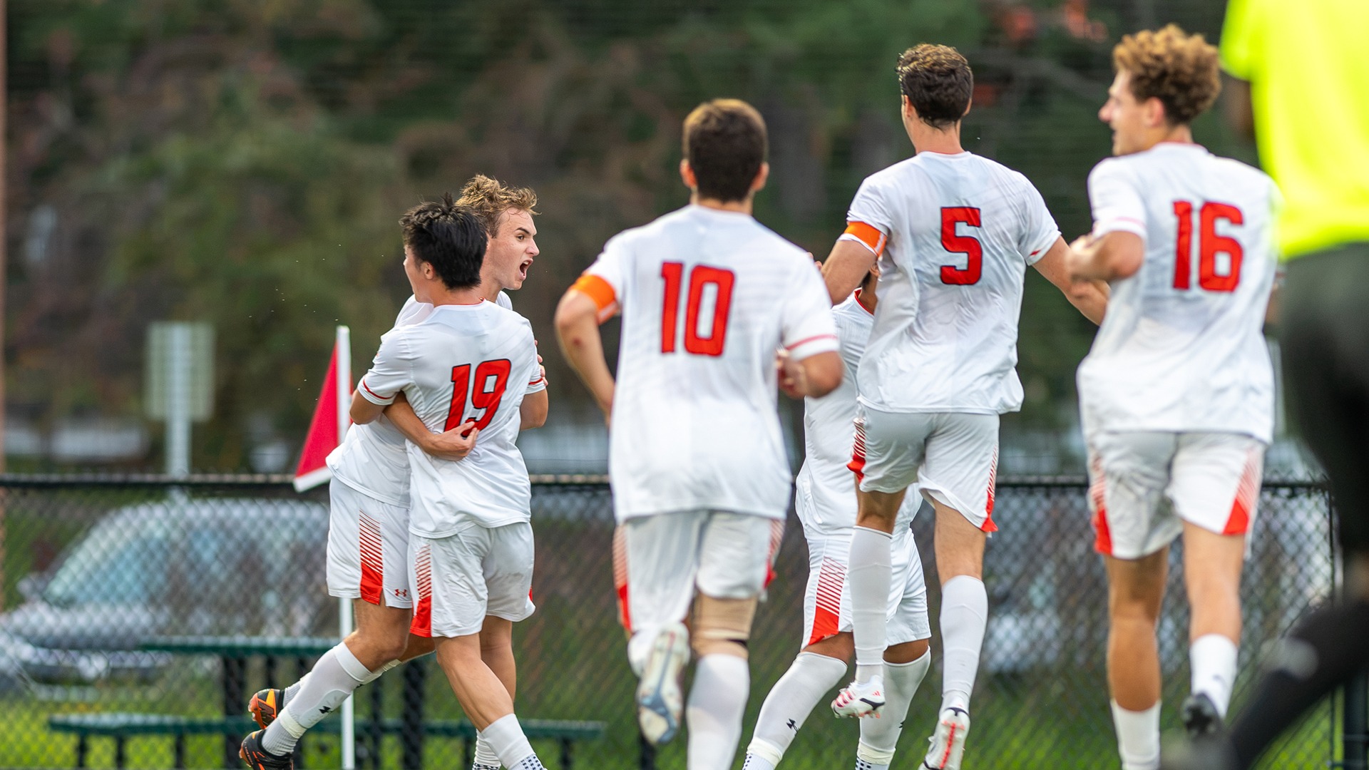 A photo of the men's soccer team celebrating a goal