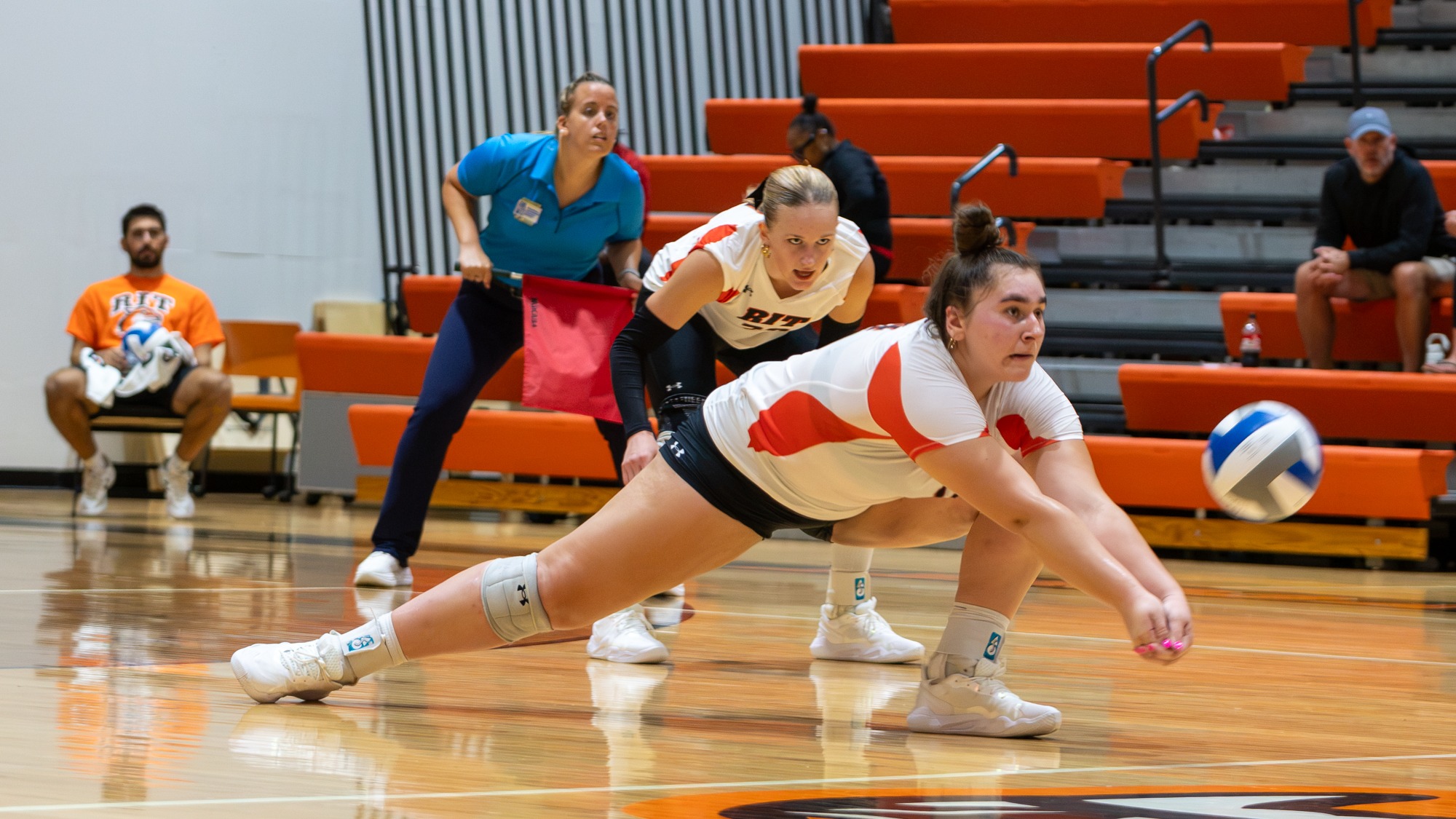 a women's volleyball player digging a ball