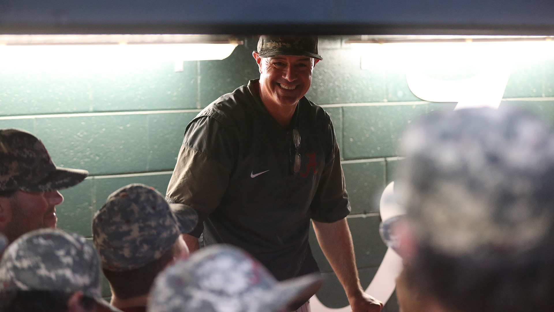 Jason Jackson standing in the dugout speaking to his players