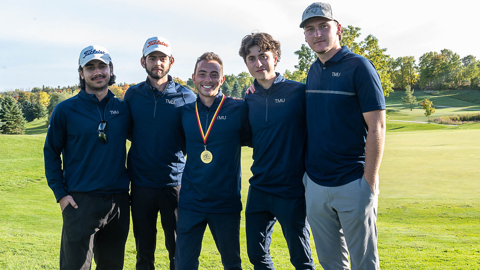 Five members of the golf team stand together for a team photo.