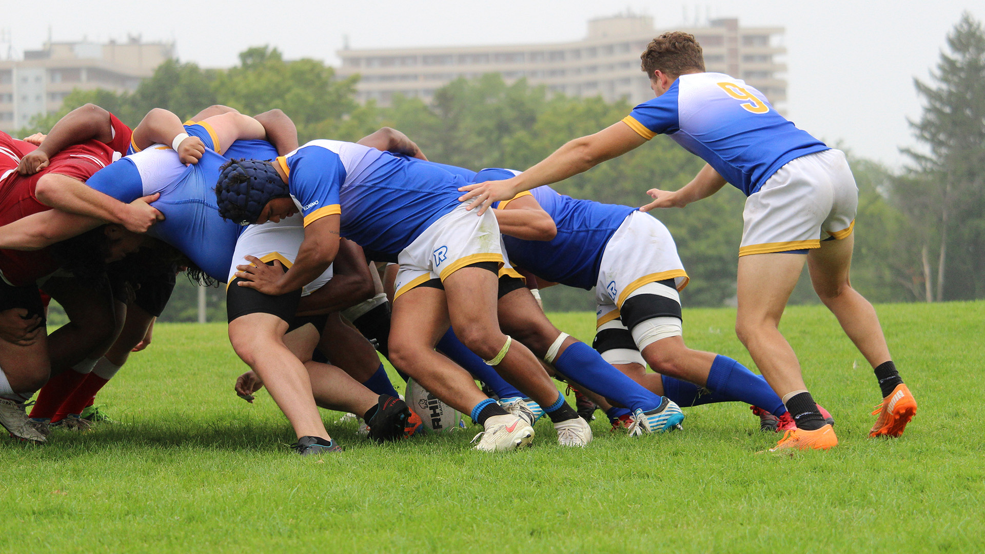 Players from TMU form a scrum.