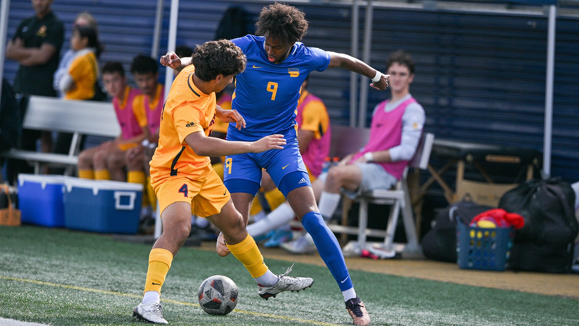 Two players battle for possession of a soccer ball.