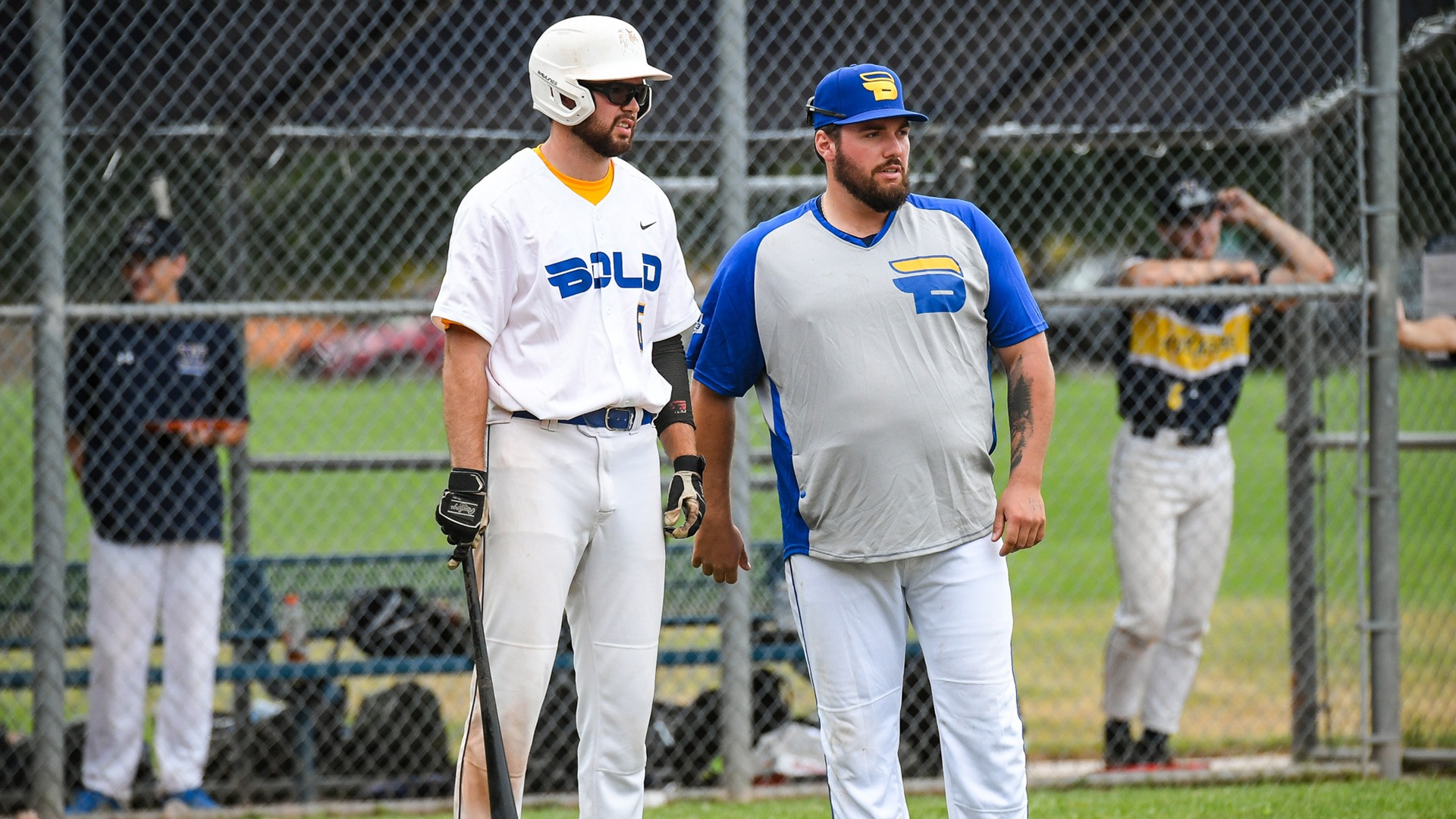 A TMU hitter and coach chat along the foul line