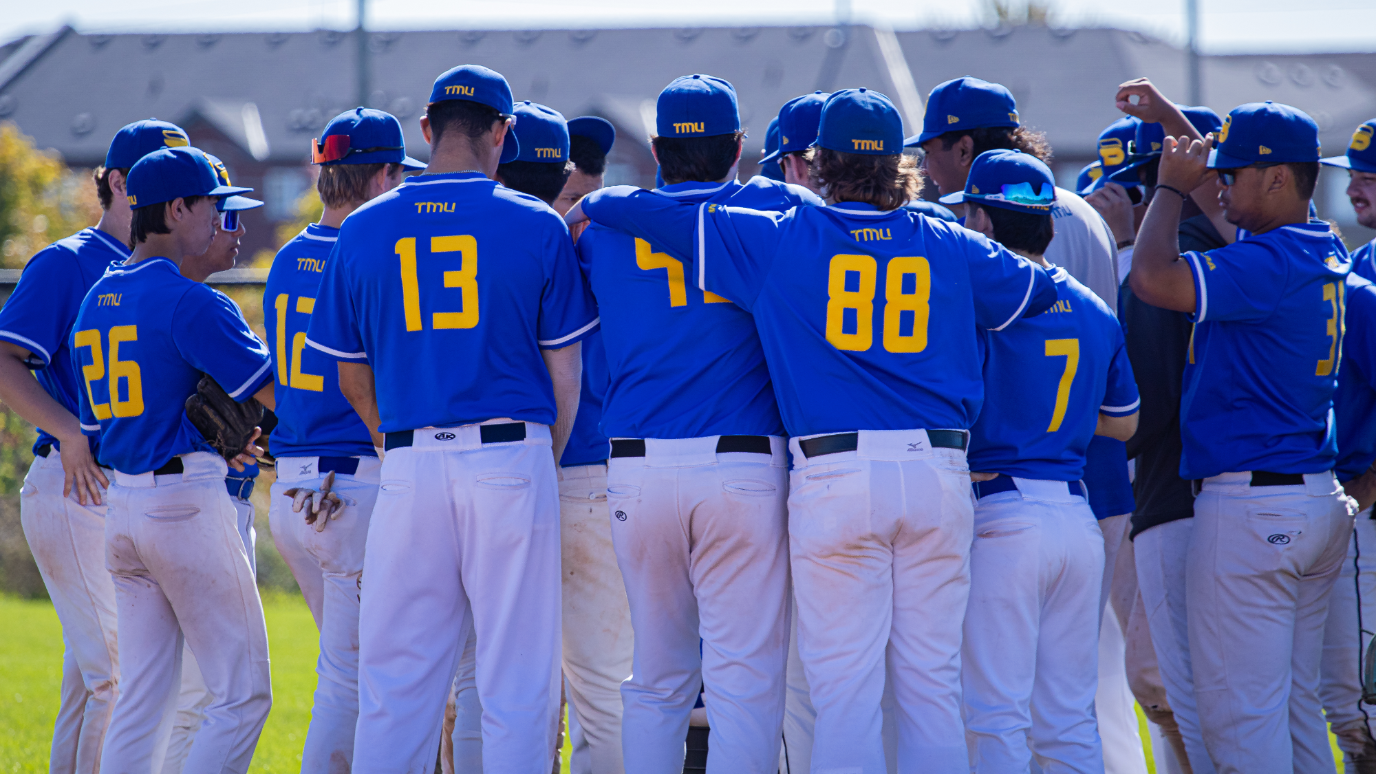 TMU Baseball Players Huddle Together