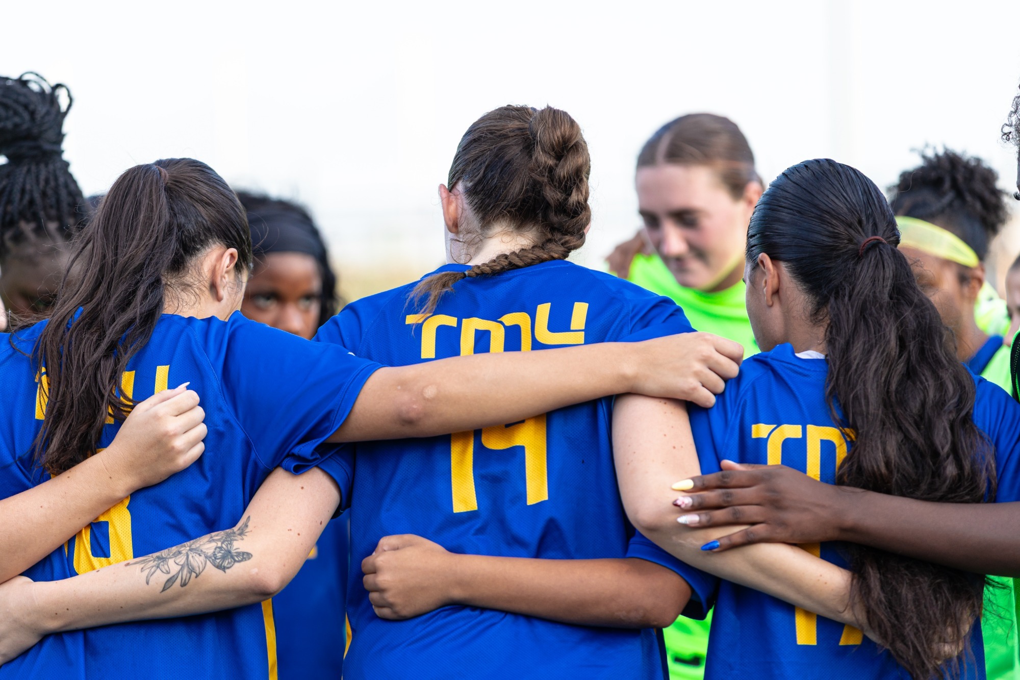 Bold women's soccer team huddle