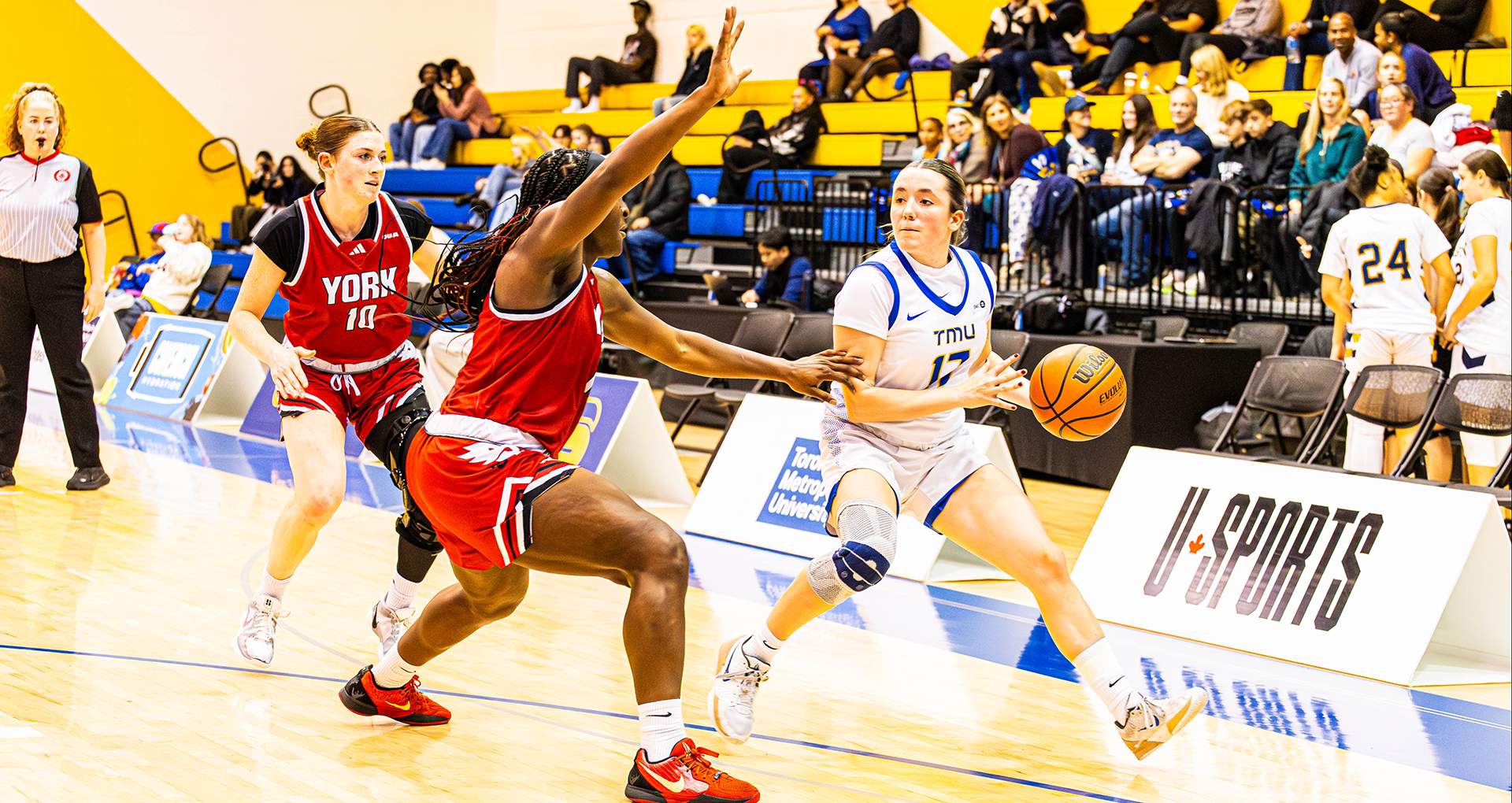 TMU Bold guard Catrina Garvey dribbles away from a York University Lions defender. 