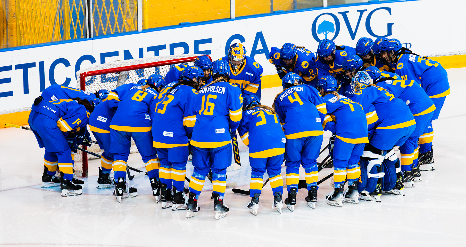 The Toronto Metropolitan University Bold women's hockey team huddles during a game against the University of Toronto Varsity Blues.