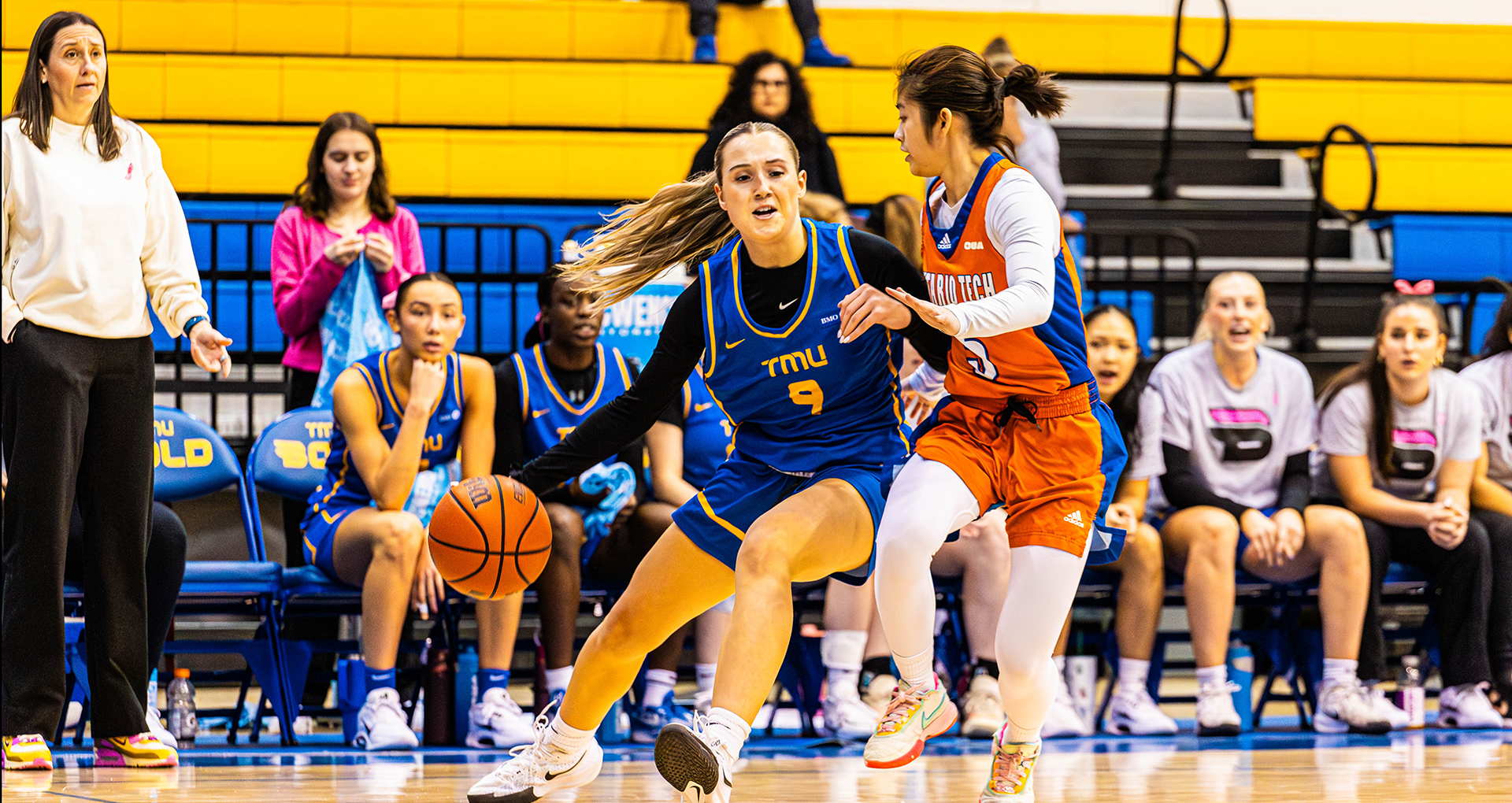 TMU Bold guard Ella McDonald dribbles past a Ontario Tech Ridgeback defender. 