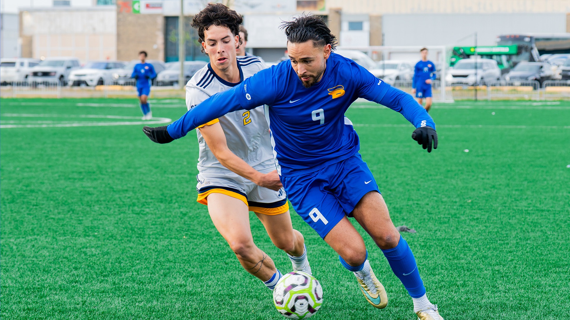 Taha Ilyass dribbles ball past a Laurentian Voyageur defender.