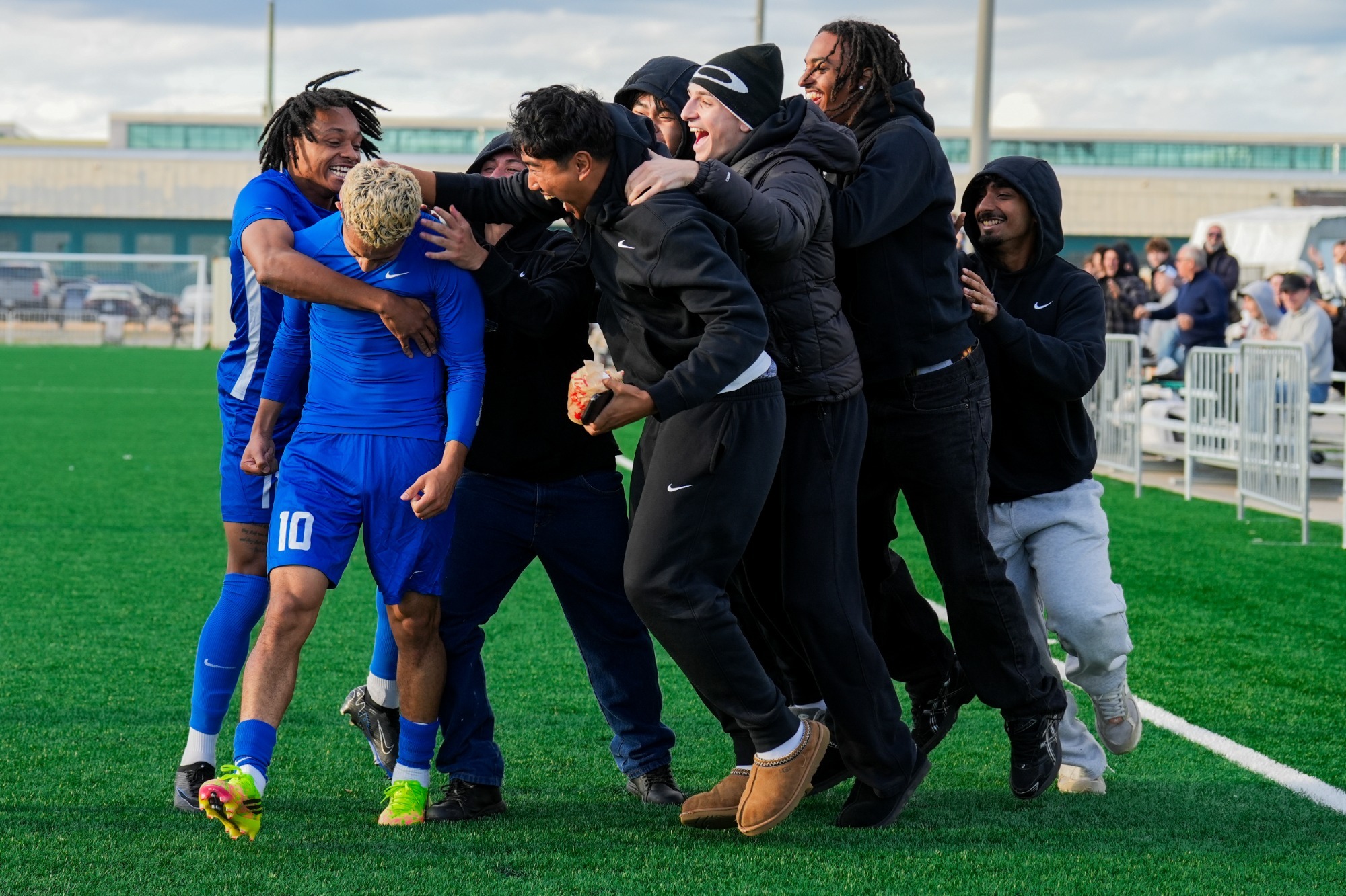 Bold midfielder Aidan Hugo is surrounded by his cheering teammates after scoring a 92nd-minute goal
