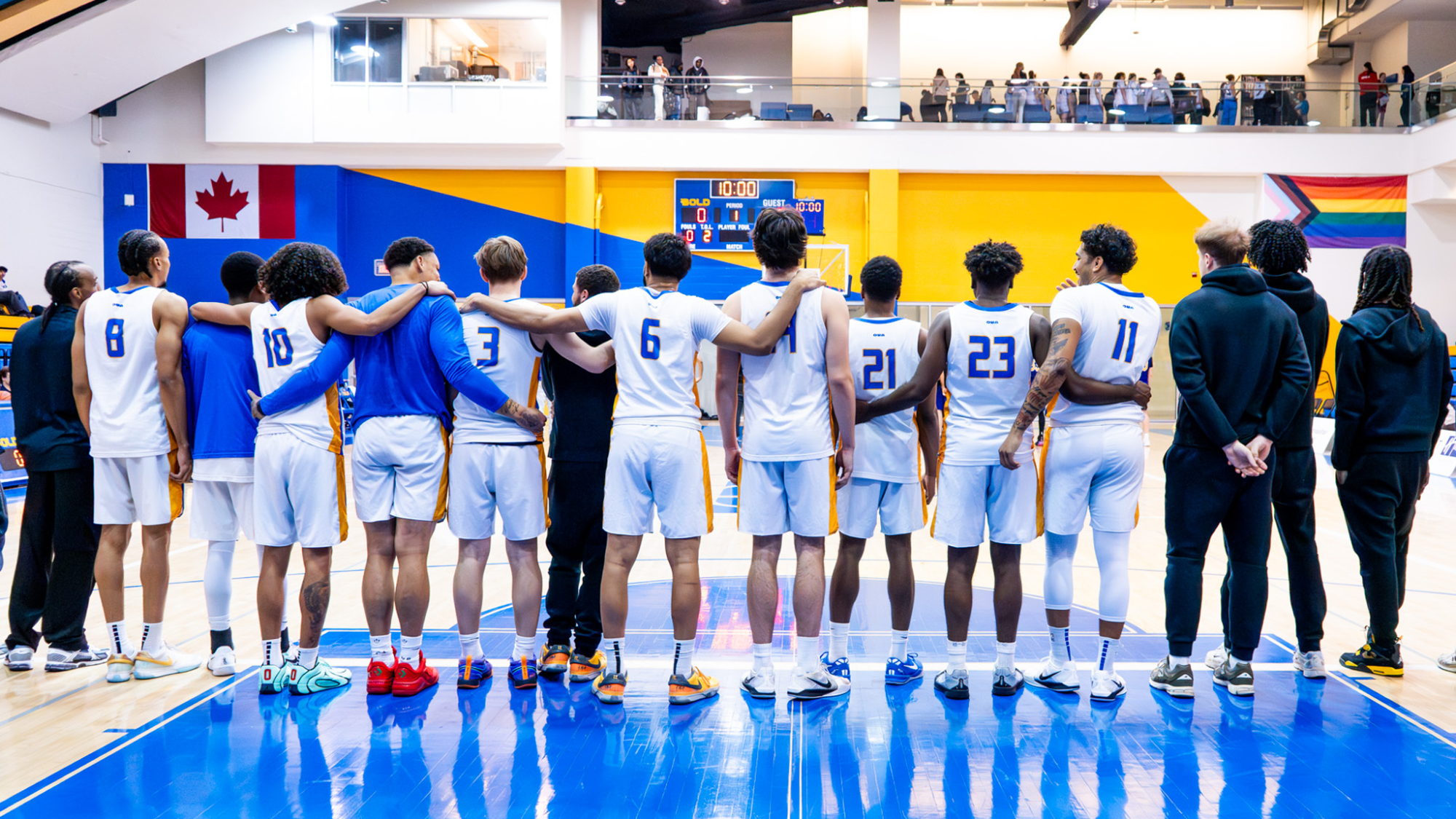 The Bold Men's Basketball Team Stands, Embracing, as the National Anthem Plays