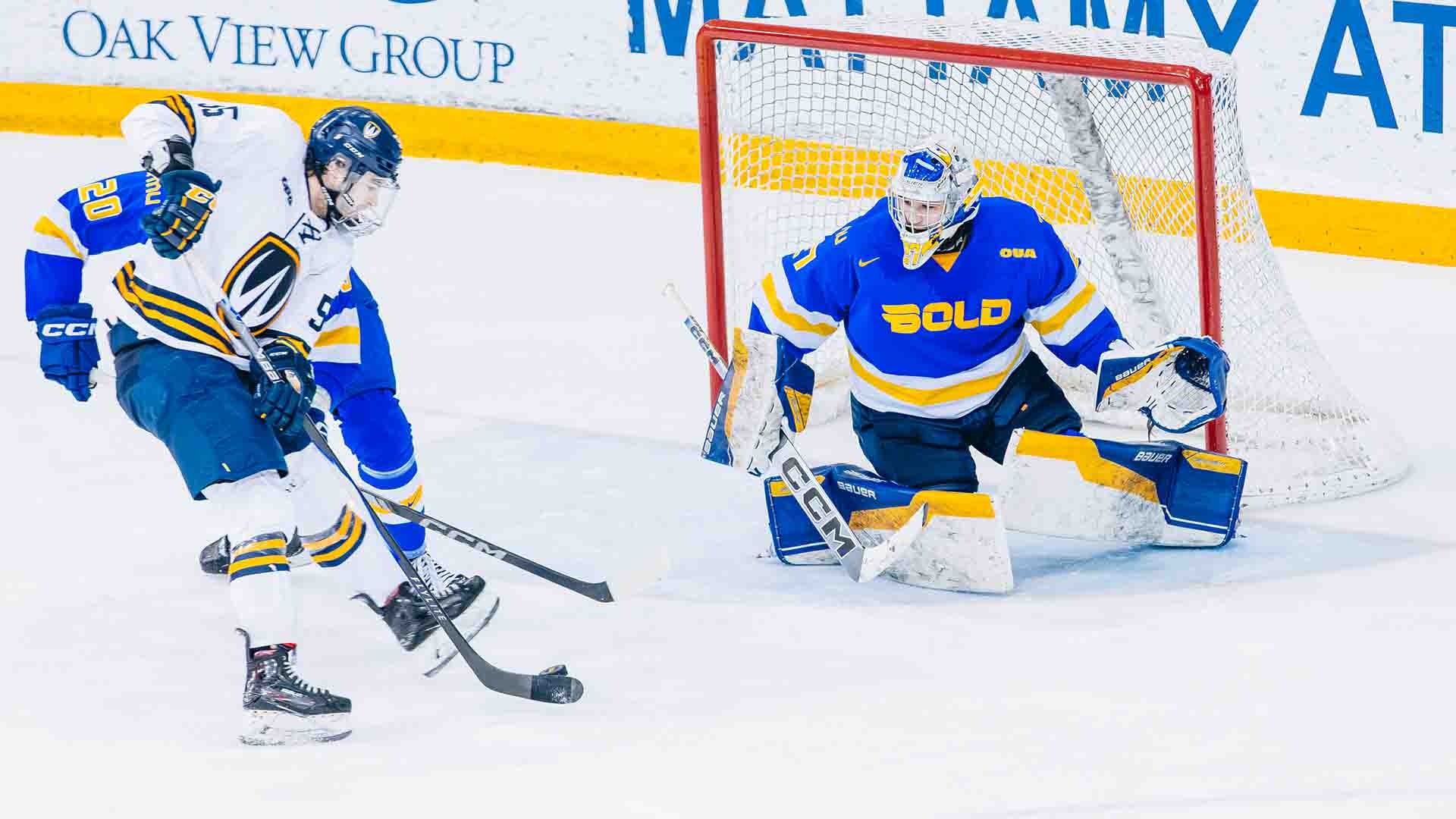 Kai Edmonds gets ready to make a save while Evan Brand defends against a Windsor forward