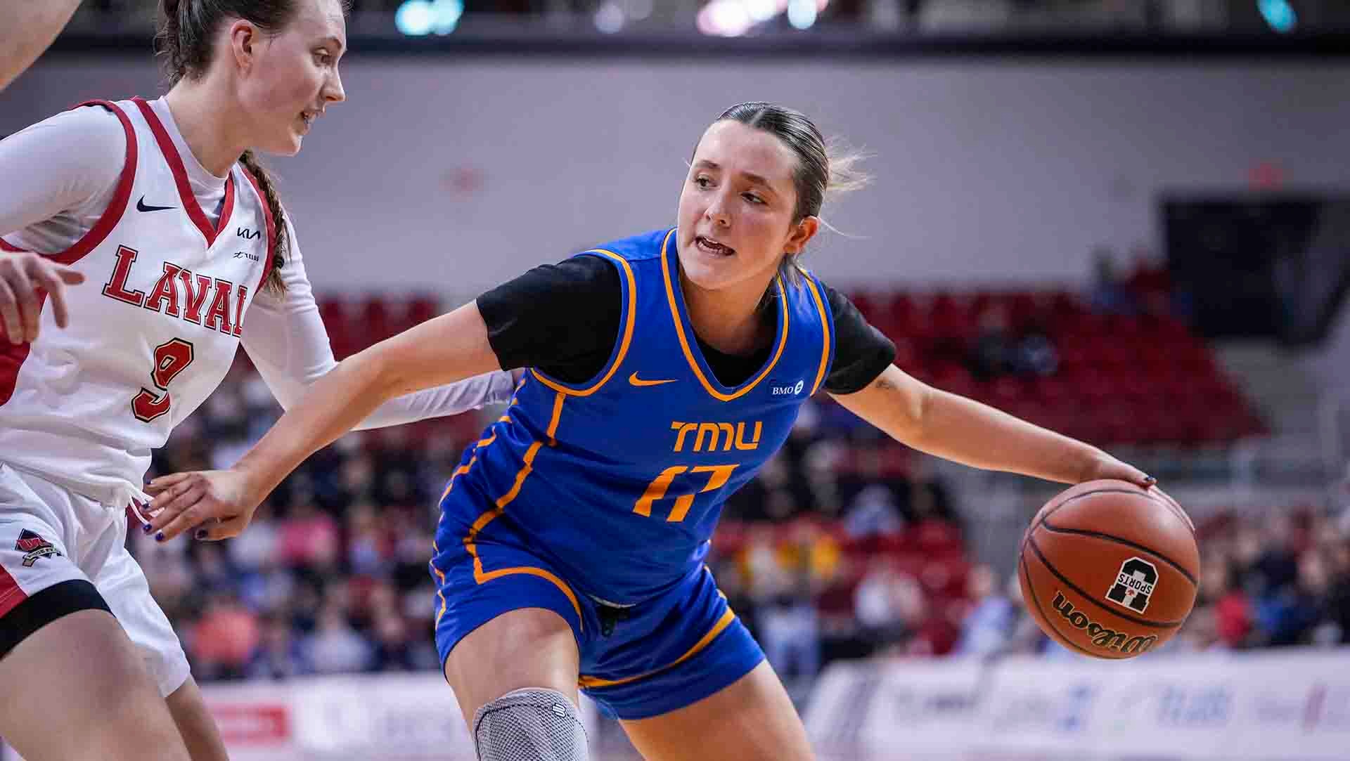 Catrina Garvey dribbles the ball while being closely guarded by a Laval defender