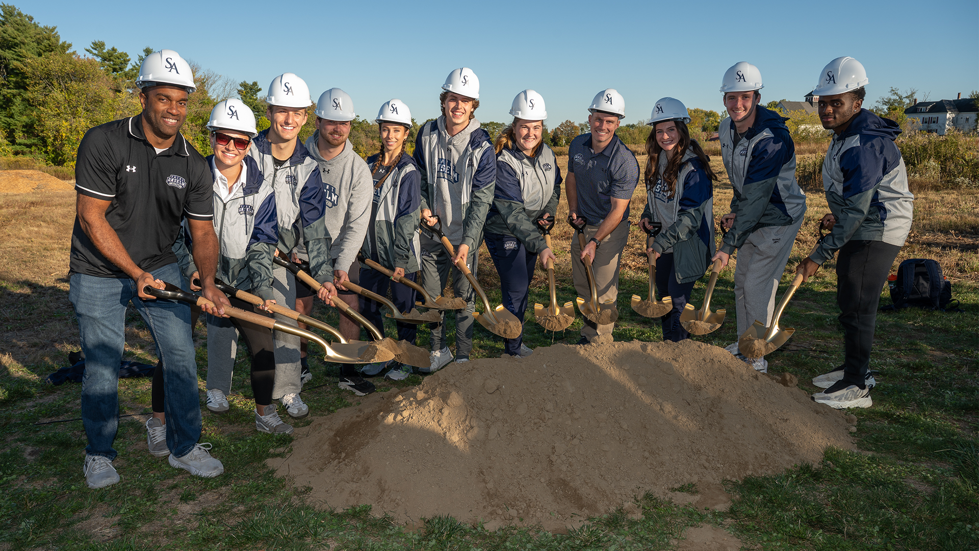 Members of the track & field program shovel dirt at Friday's groundbreaking ceremony