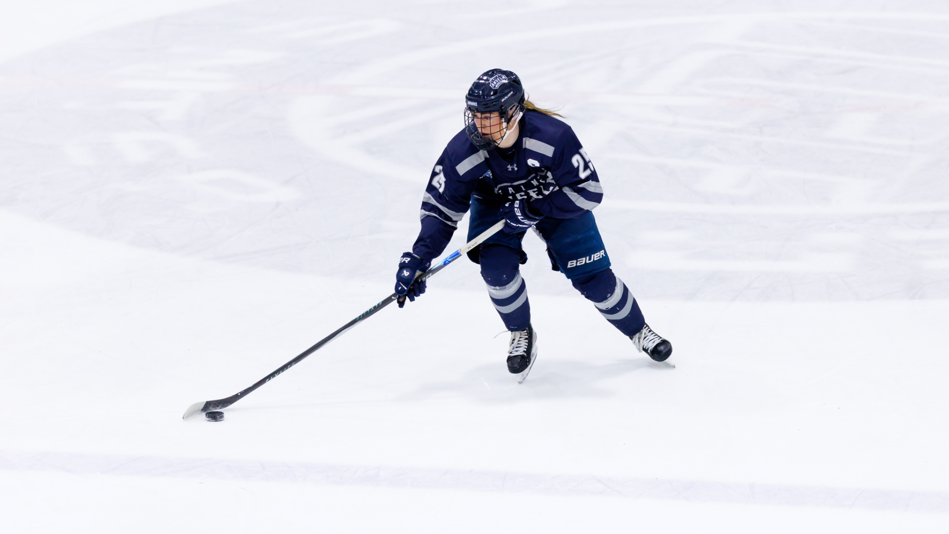 Brooklyn Schneiderhan skates with puck