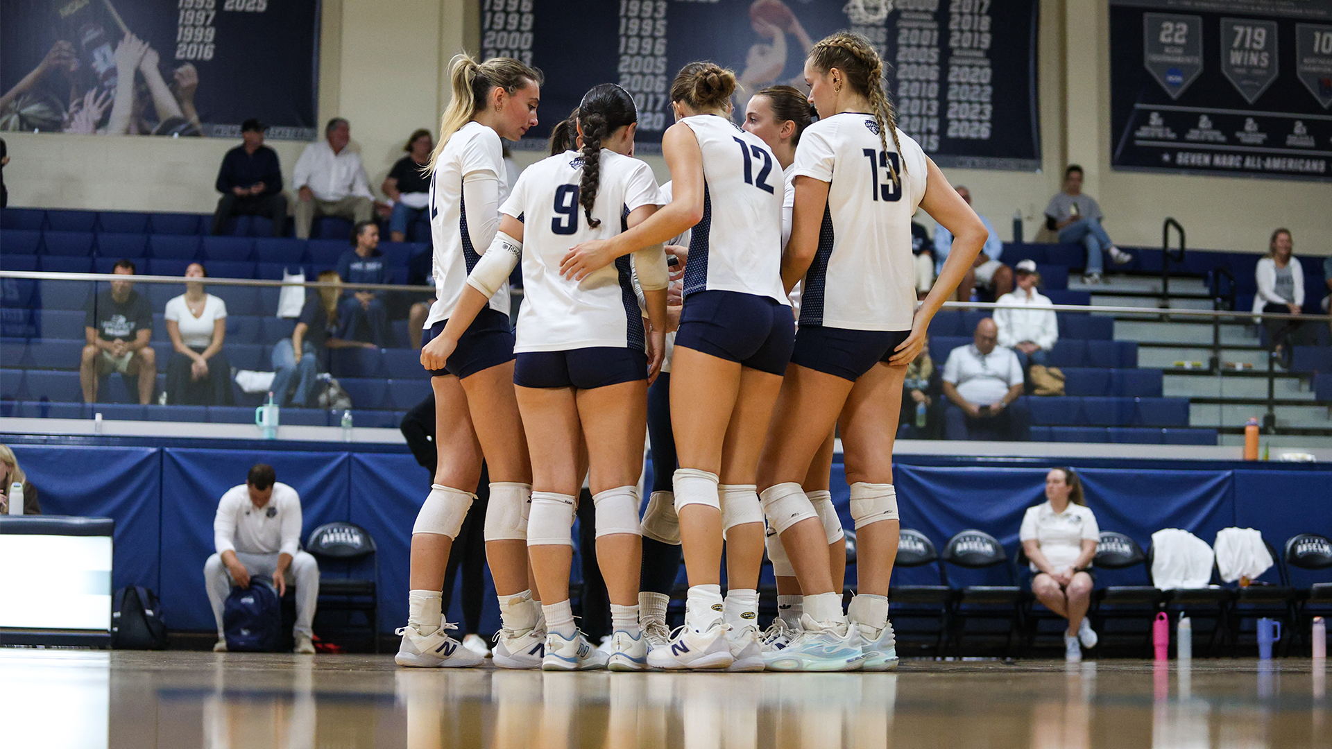 Women's volleyball players huddle before play