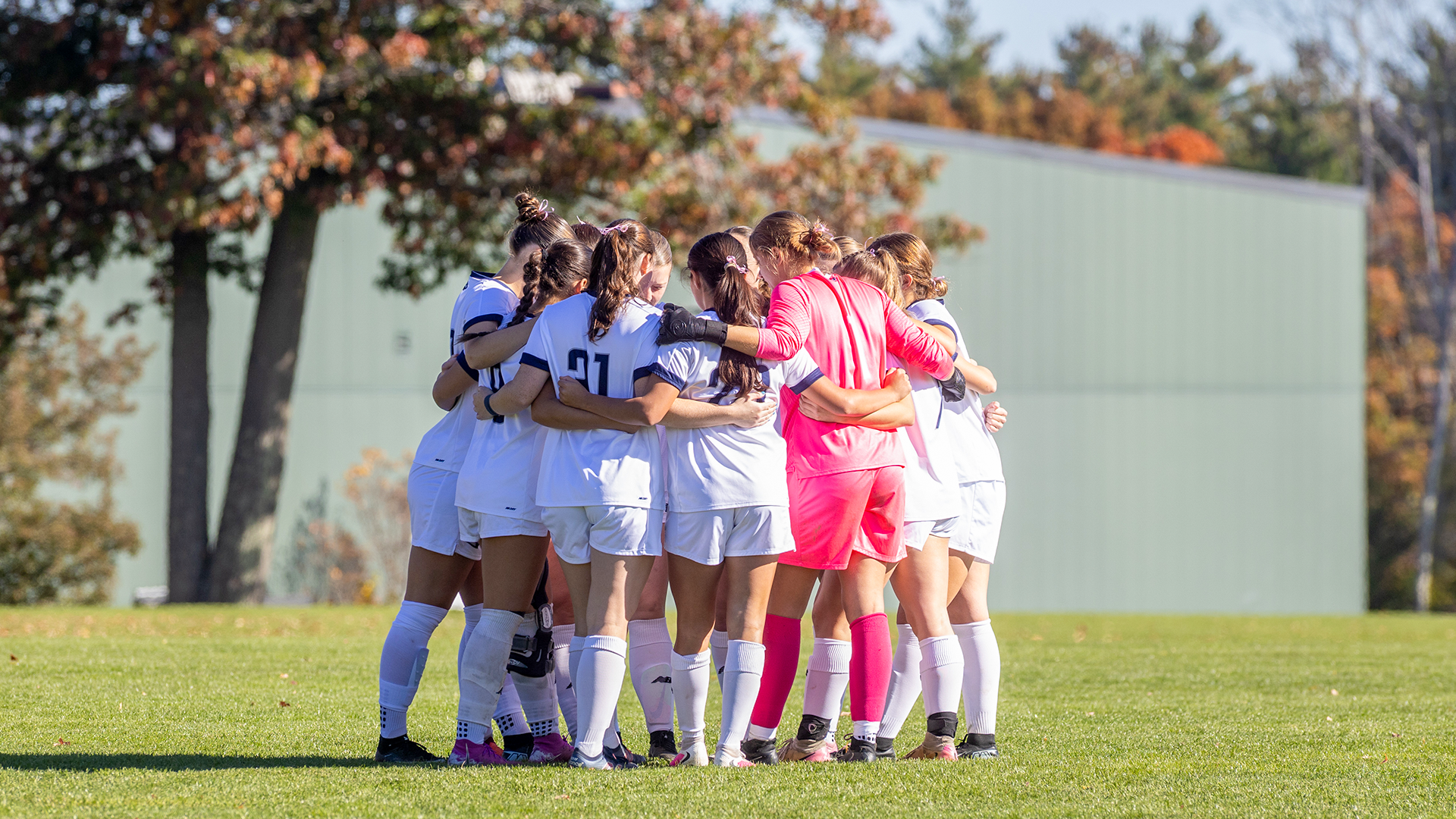 Women's soccer huddles before a game. 