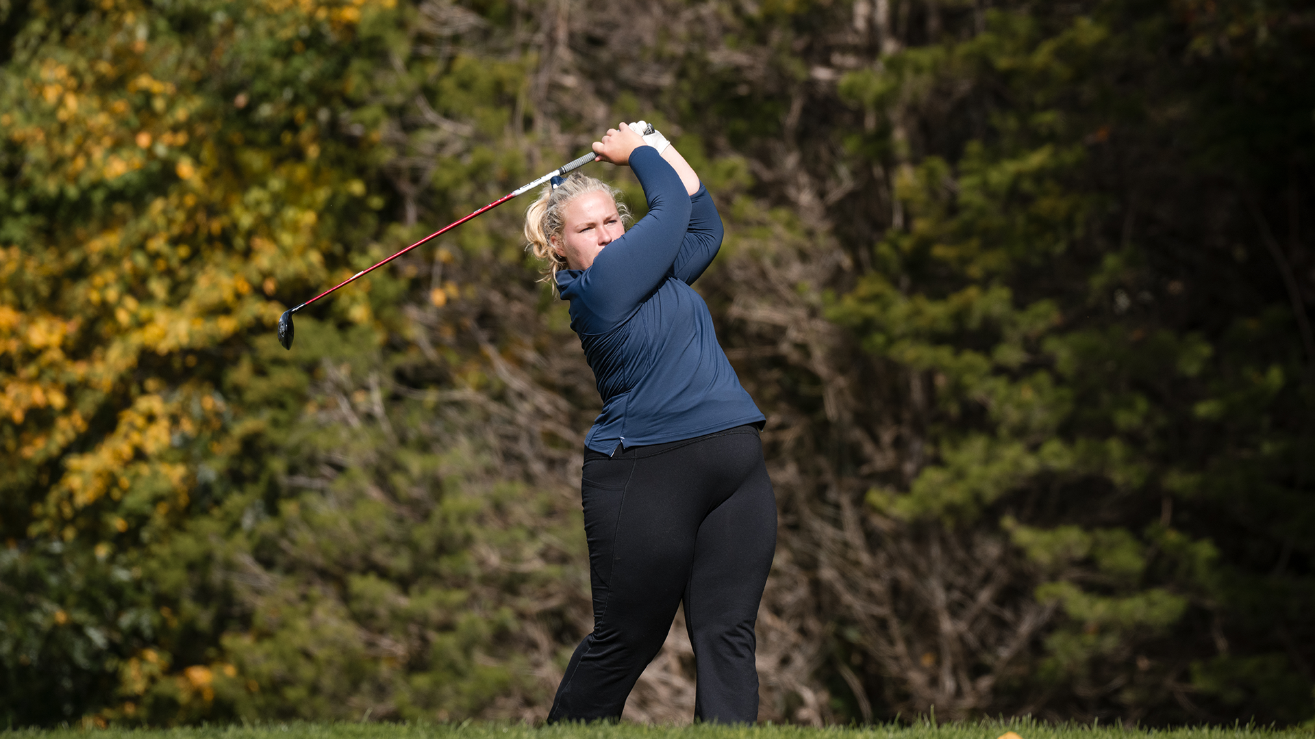 Lilla hitting the golf ball. 