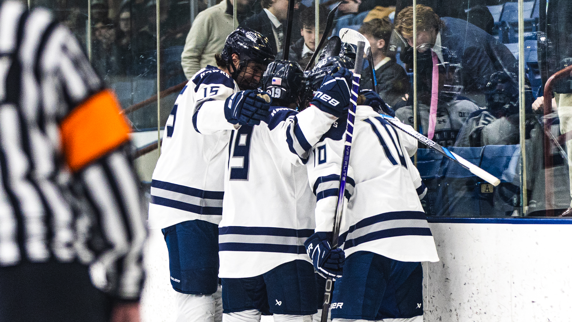 Men's ice hockey players celebrate goal