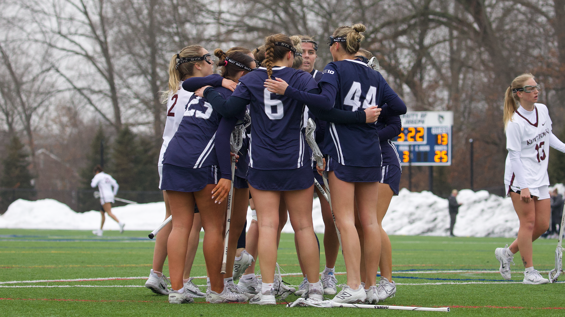 Women's lacrosse players celebrate goal