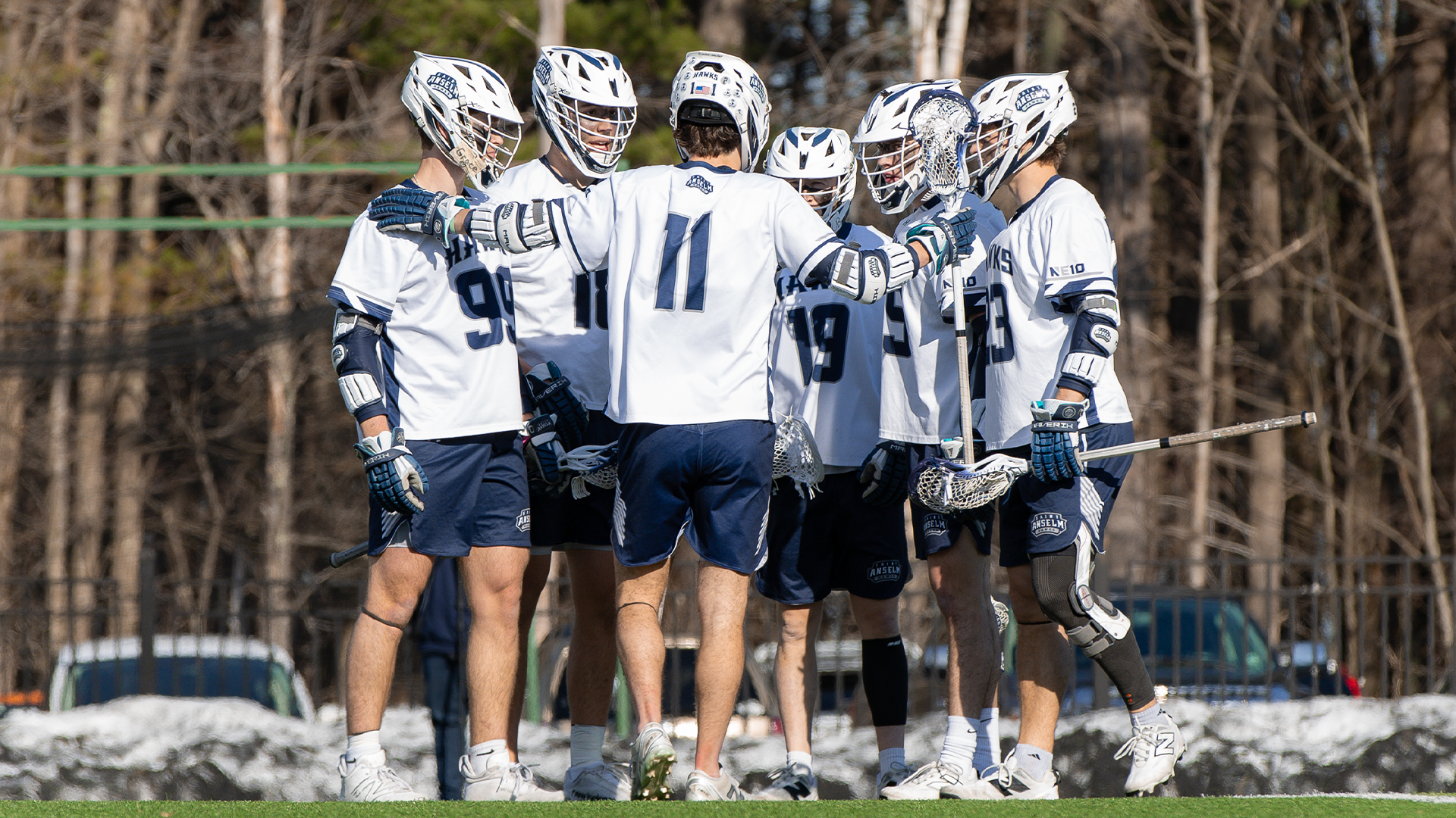 Members of men's lacrosse team huddle