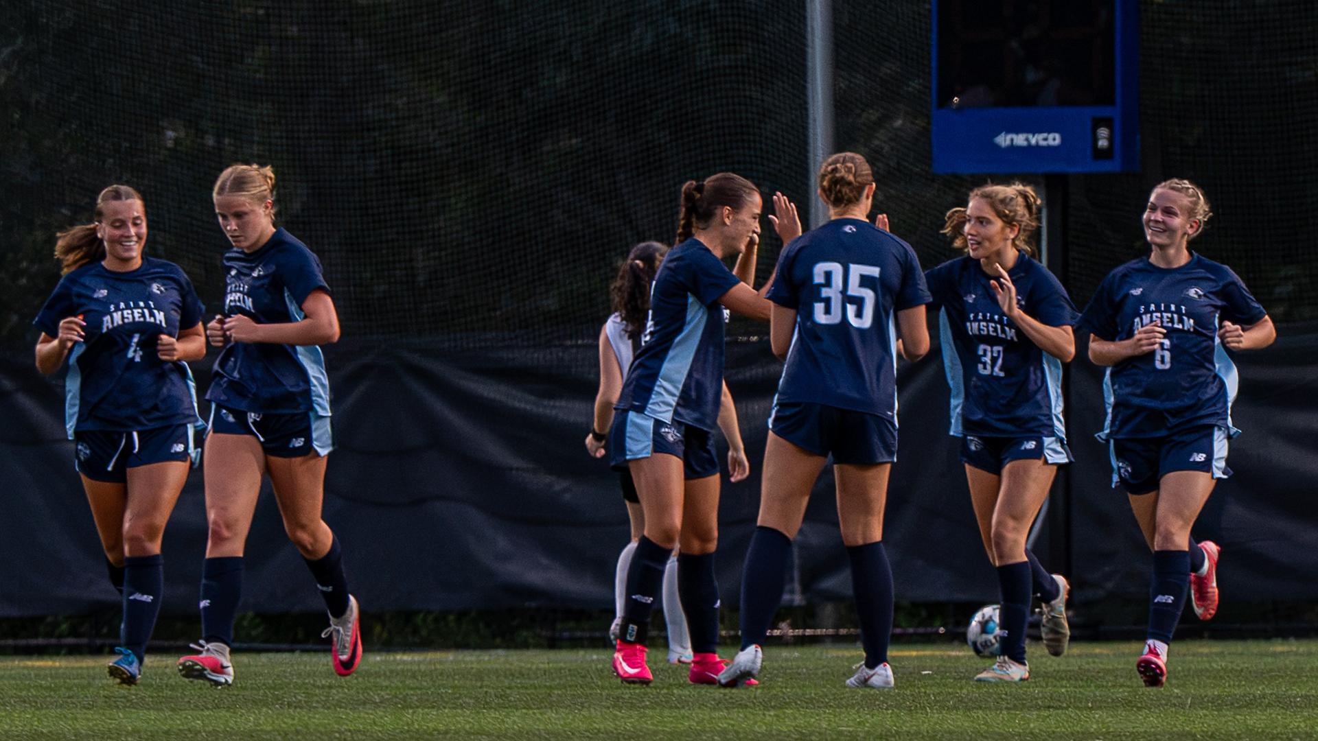 Women's soccer players celebrate a goal