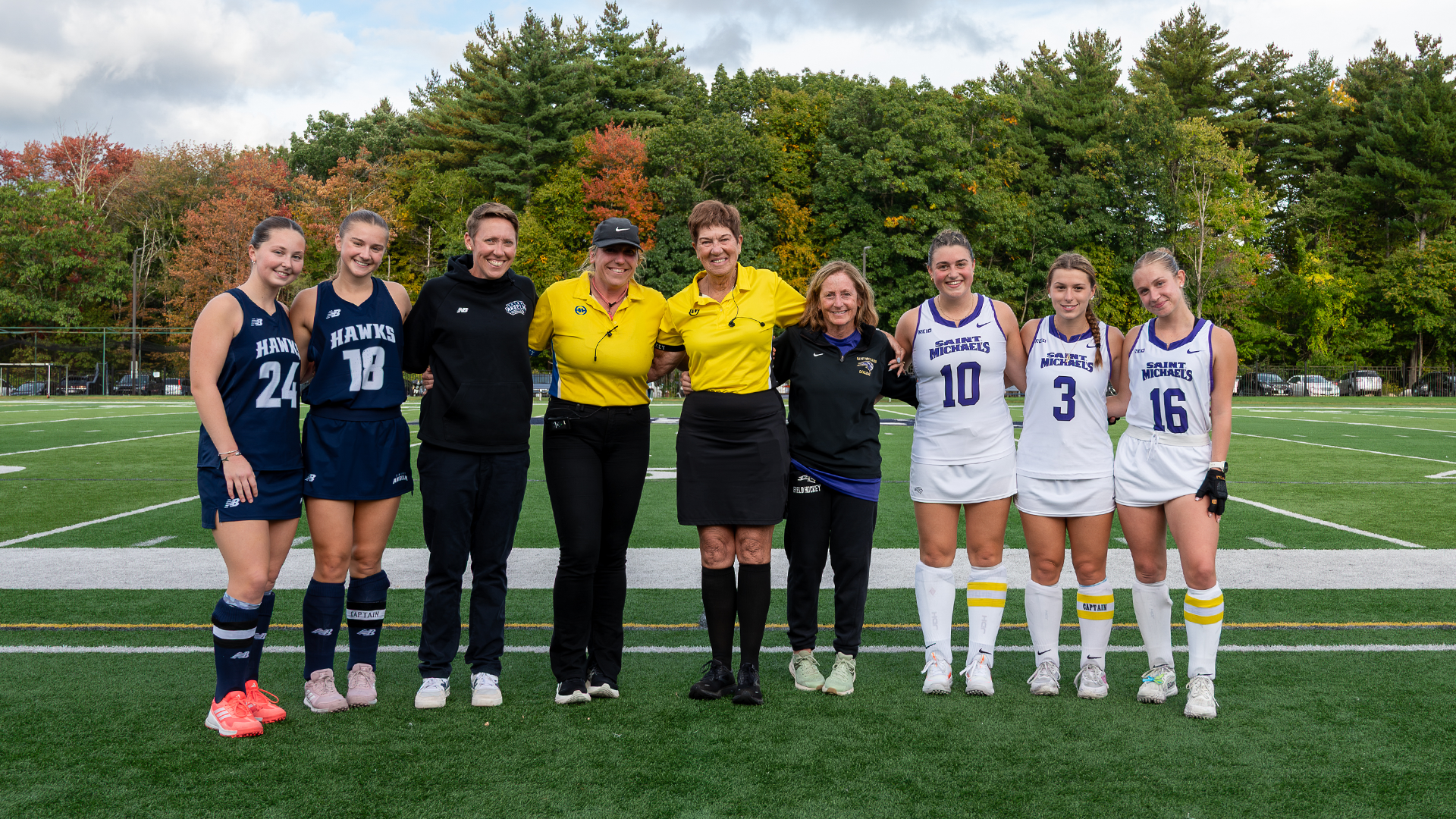 Saint Anselm and Saint Michael's head coaches and captains pose for photos with game umpires to celebrate NFHCA Umpire Appreciation Week