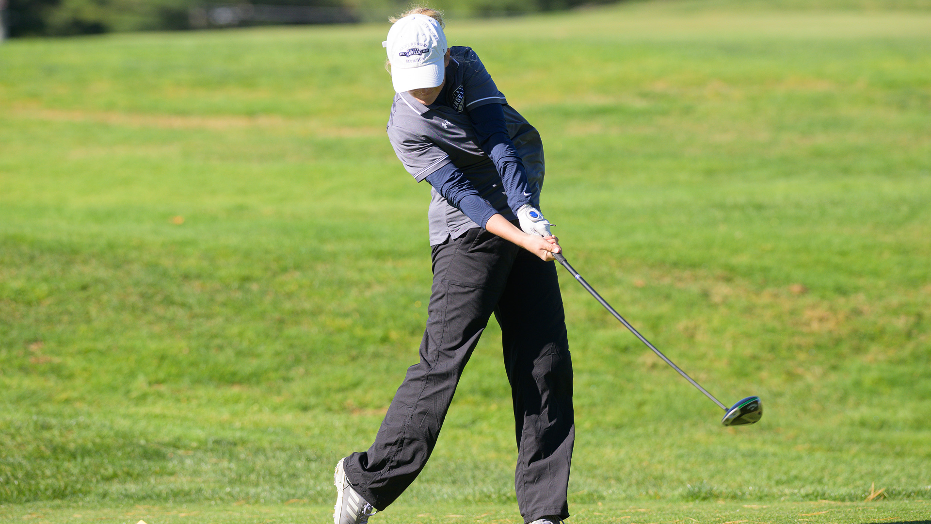 Women's golf player swings club at invite