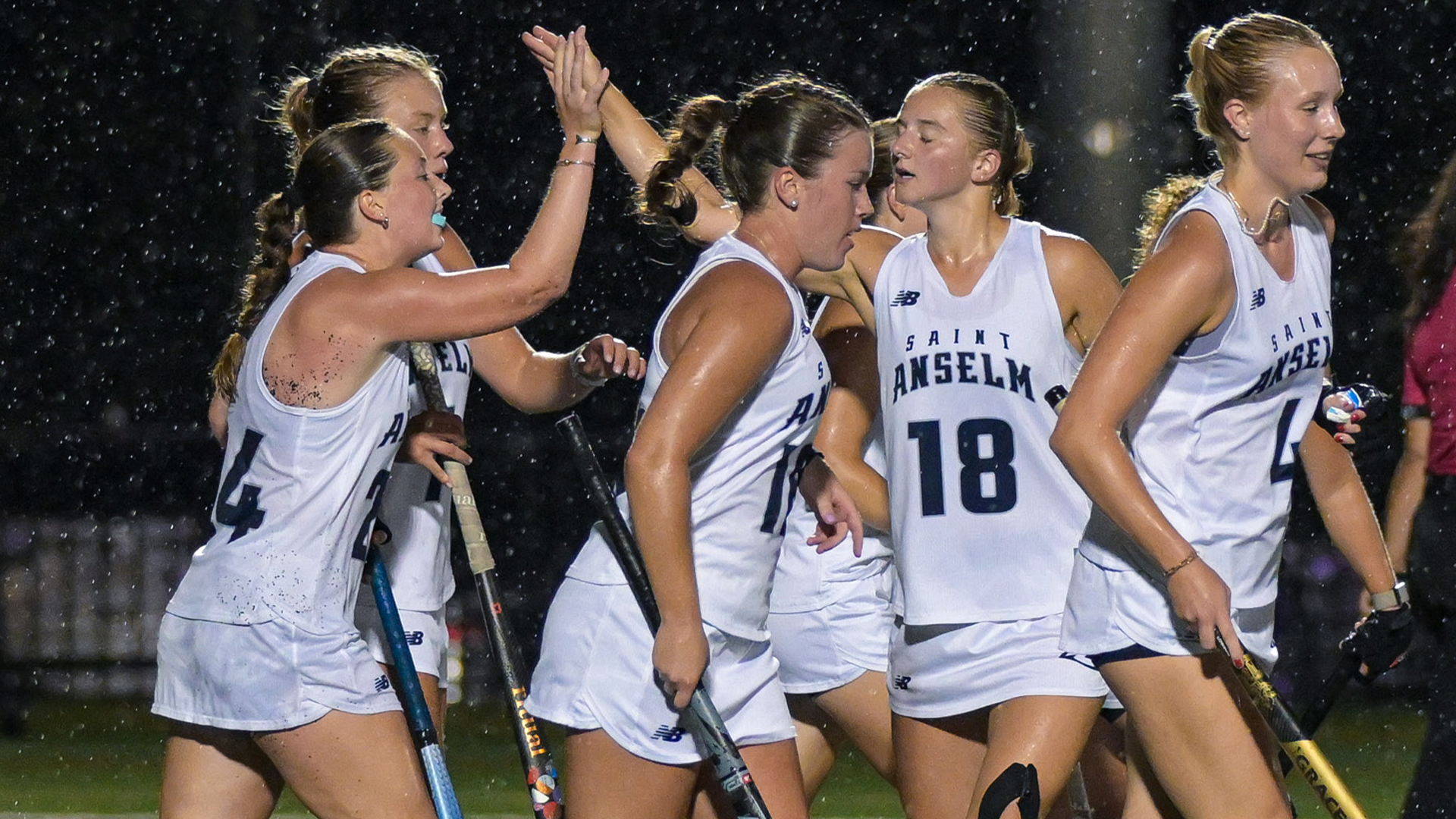 Field hockey players celebrate goal