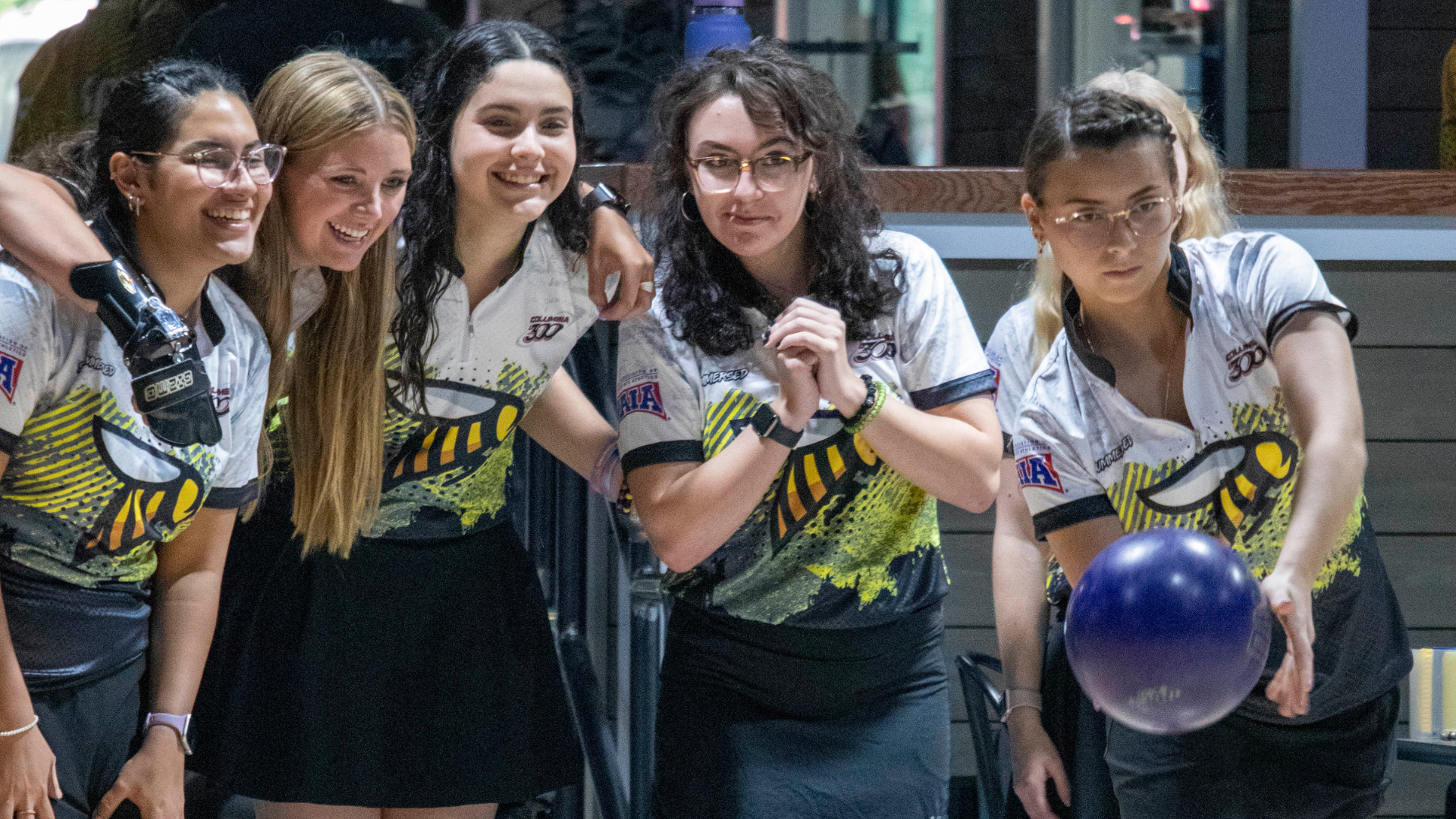 The SCAD Women's bowling team looks on as a teammate gears up.