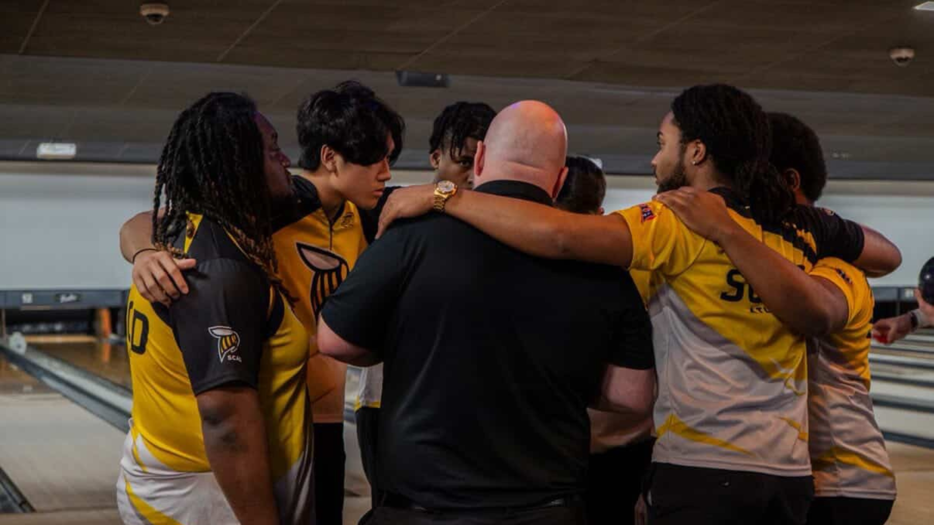 The men's bowling team huddle up at Conference.