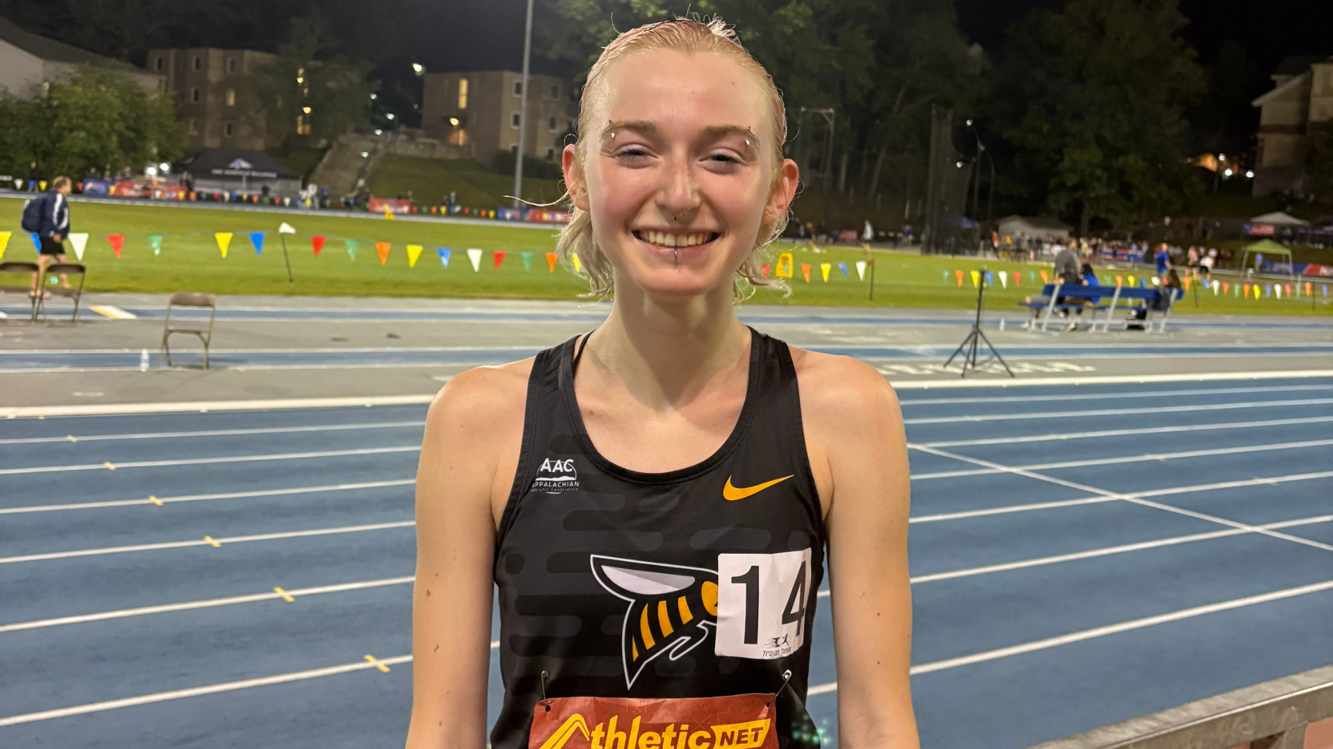 Avery Raymond poses with the track behind her the NAIA Outdoor Nationals.
