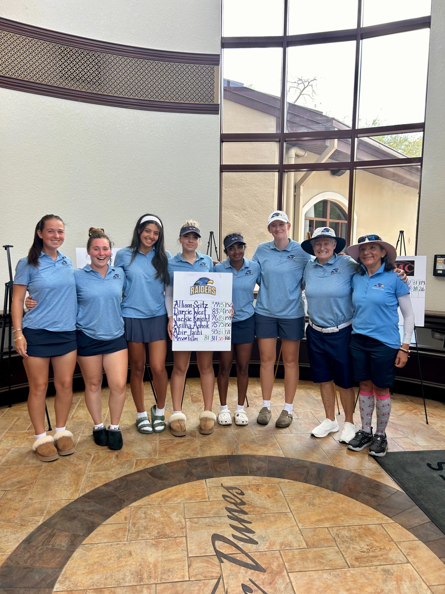 Group of golf players standing next to each other with an award