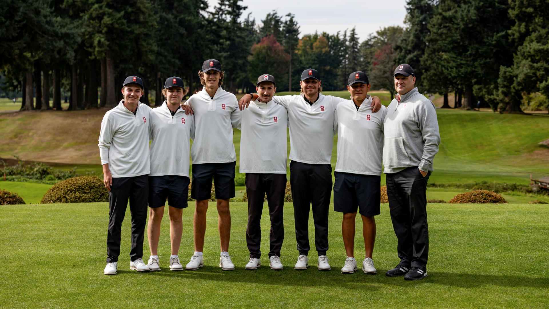 The 2025-26 Men's Golf team smiles for a photo together on the course. 