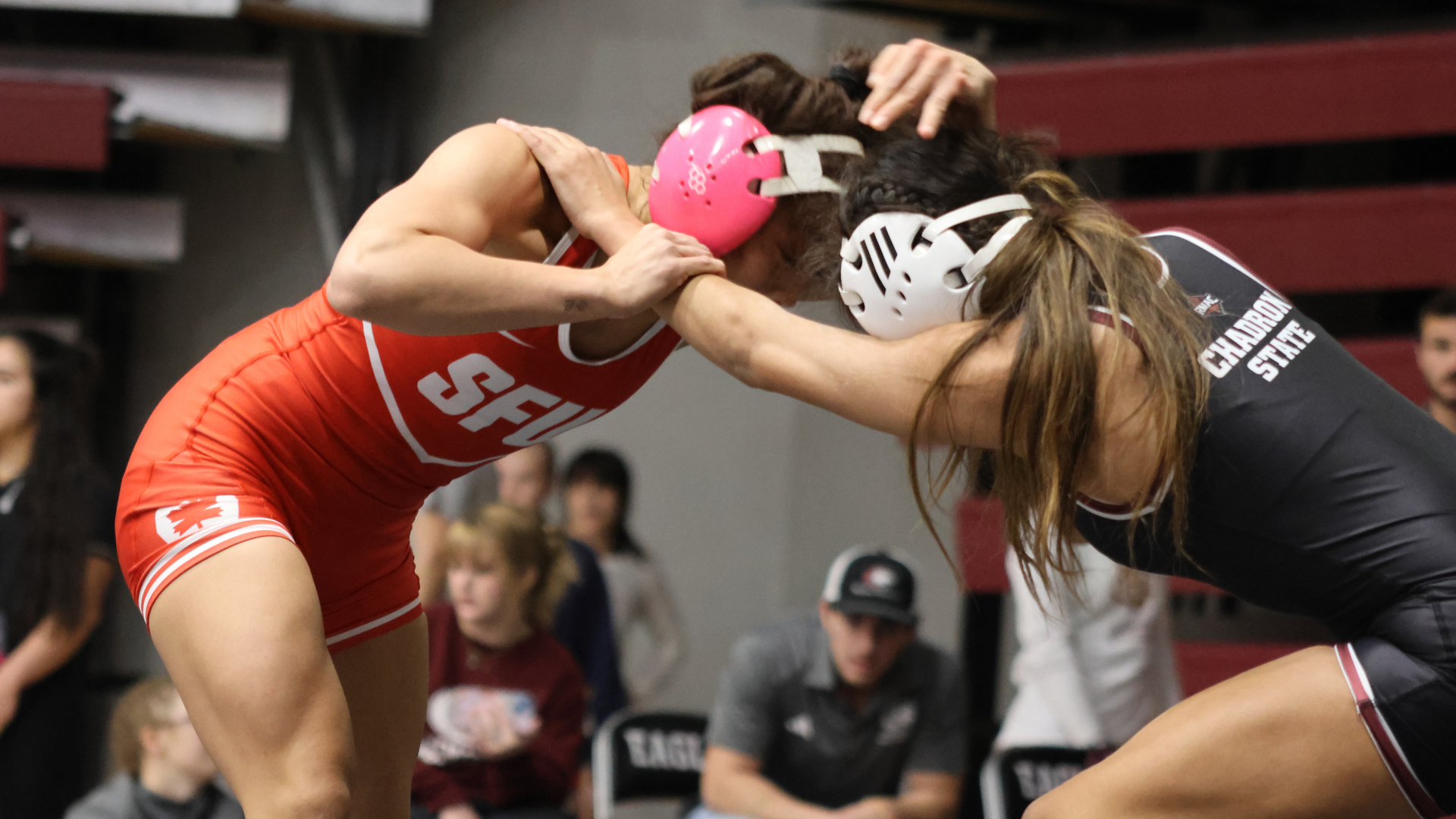 An SFU women's wrestler locks arms with an opponent mid-match
