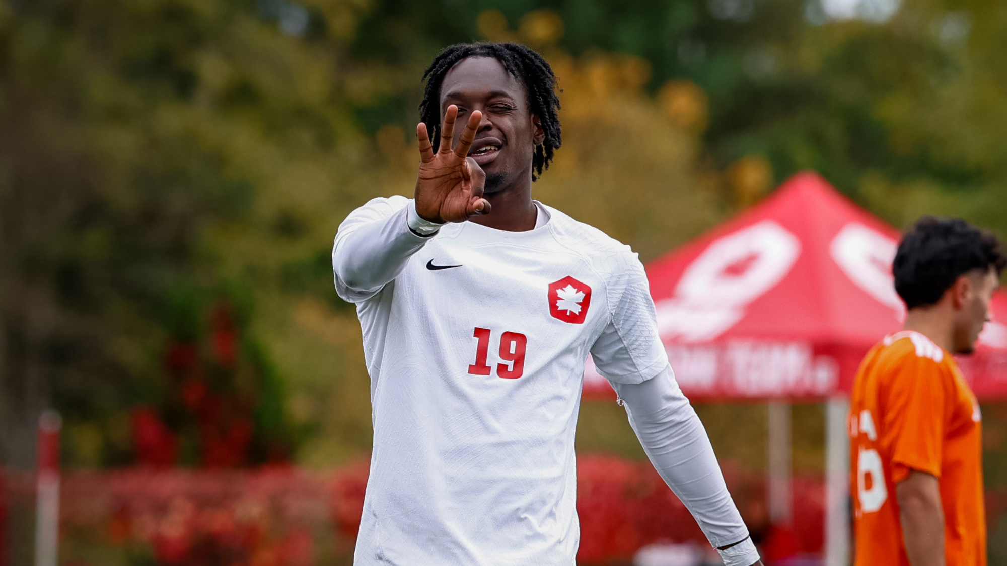 Kundalini Dominique smiles for the camera and holds out three fingers after scoring three goals