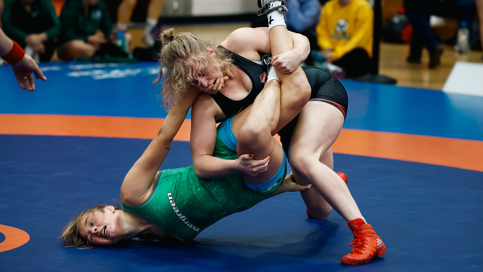 SFU's Liv Wieber wrestles a competitor on a blue mat.