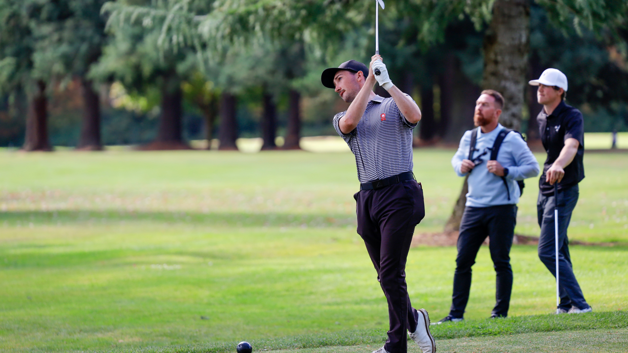 Golfer Denby Carswell follows through off the tee box.