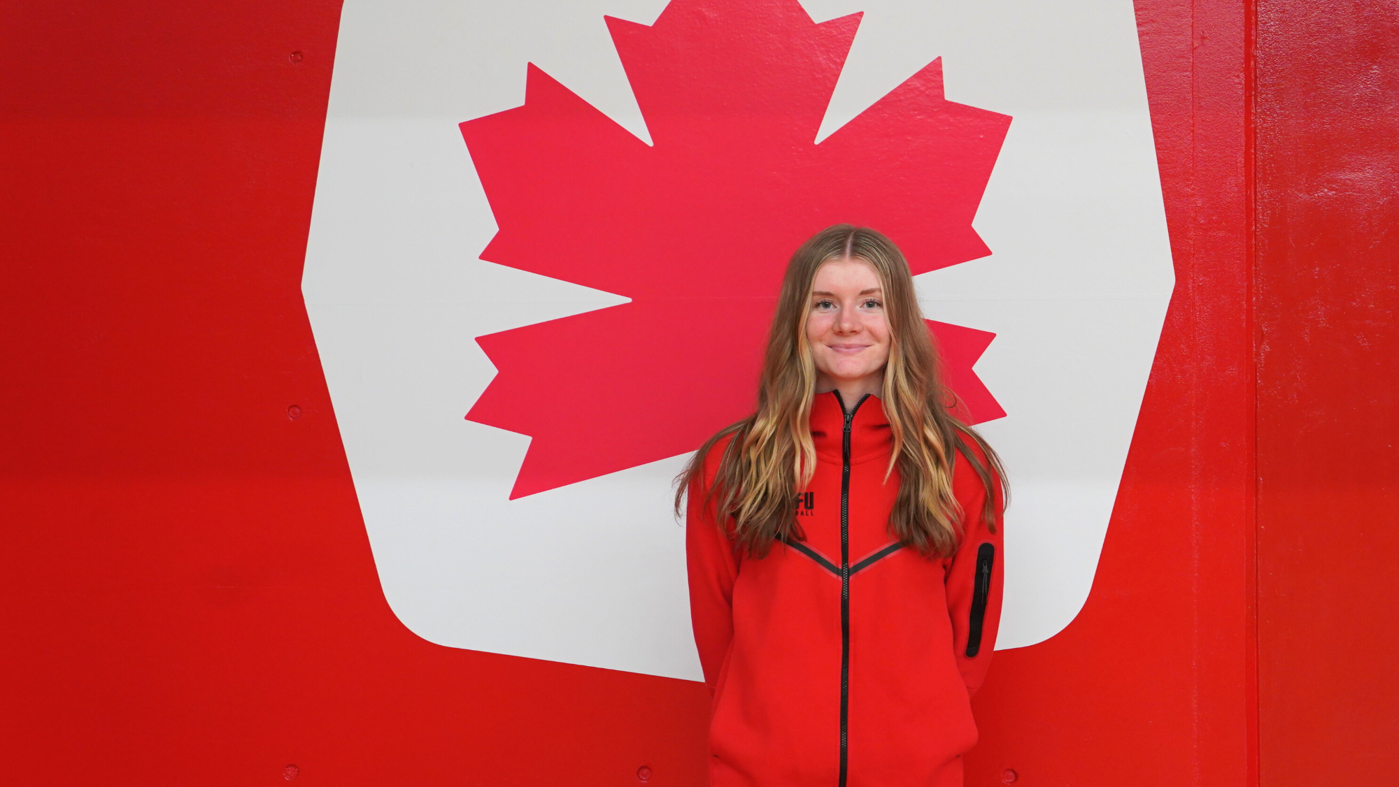 Rachel Loukes stands in front of the Red Leaf icon.