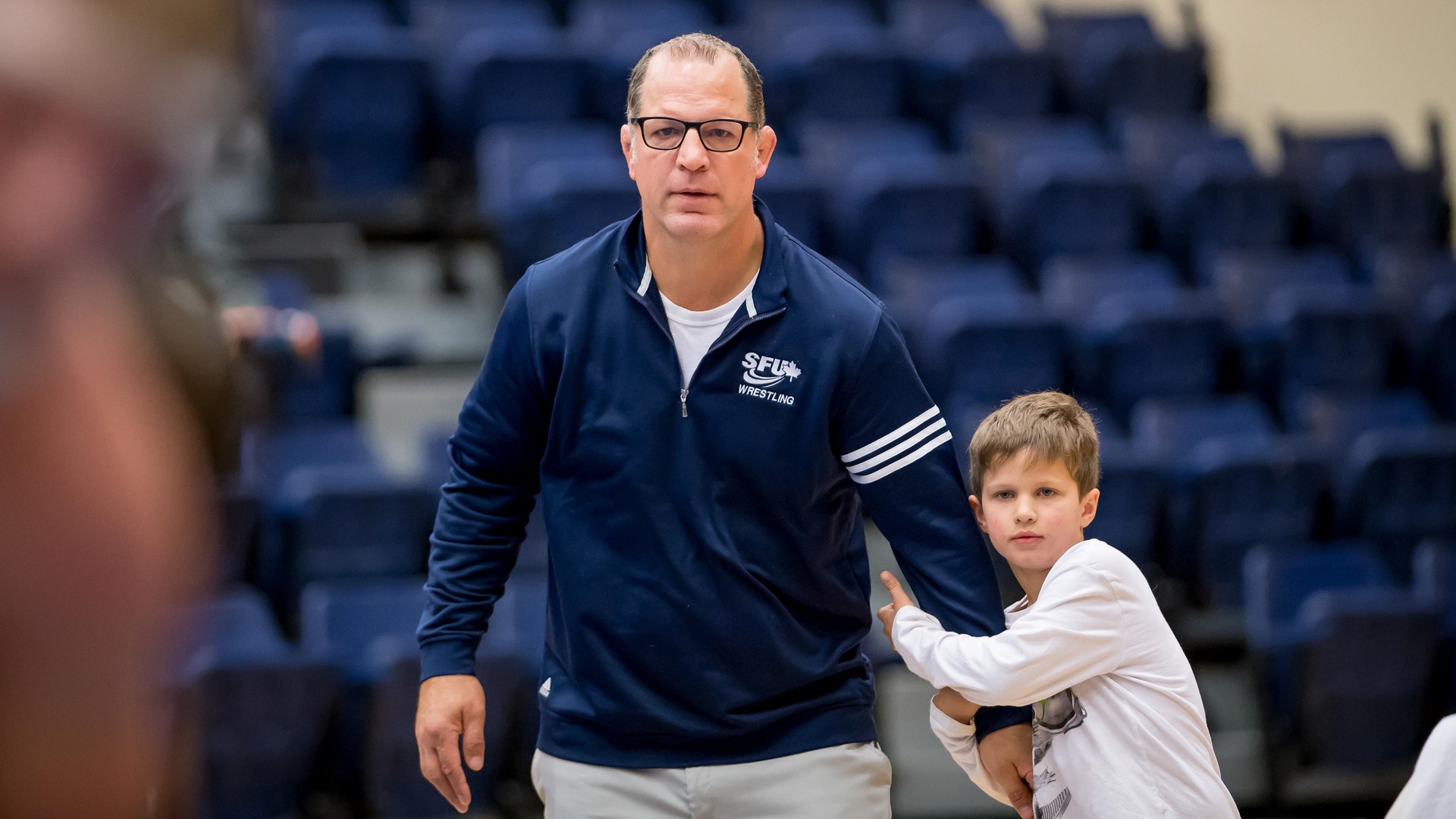 Justin Abdou with his son during a men's dual match between SFU and North Idaho College inside the West Gym, Nov. 10, 2017