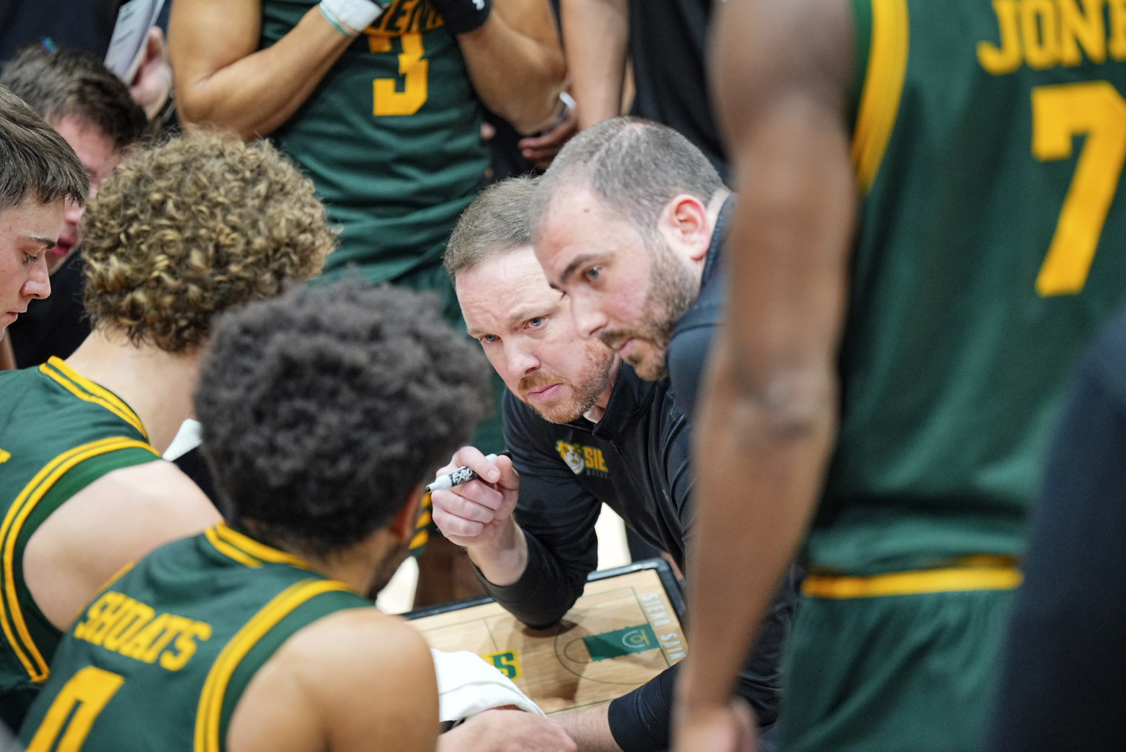 Coach McNamara Coach Lee team huddle