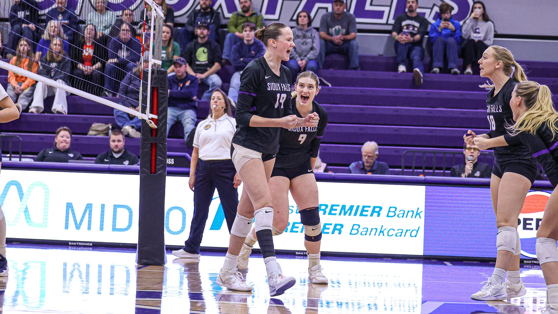 Ella Walker and teammates celebrate following a kill against UMary