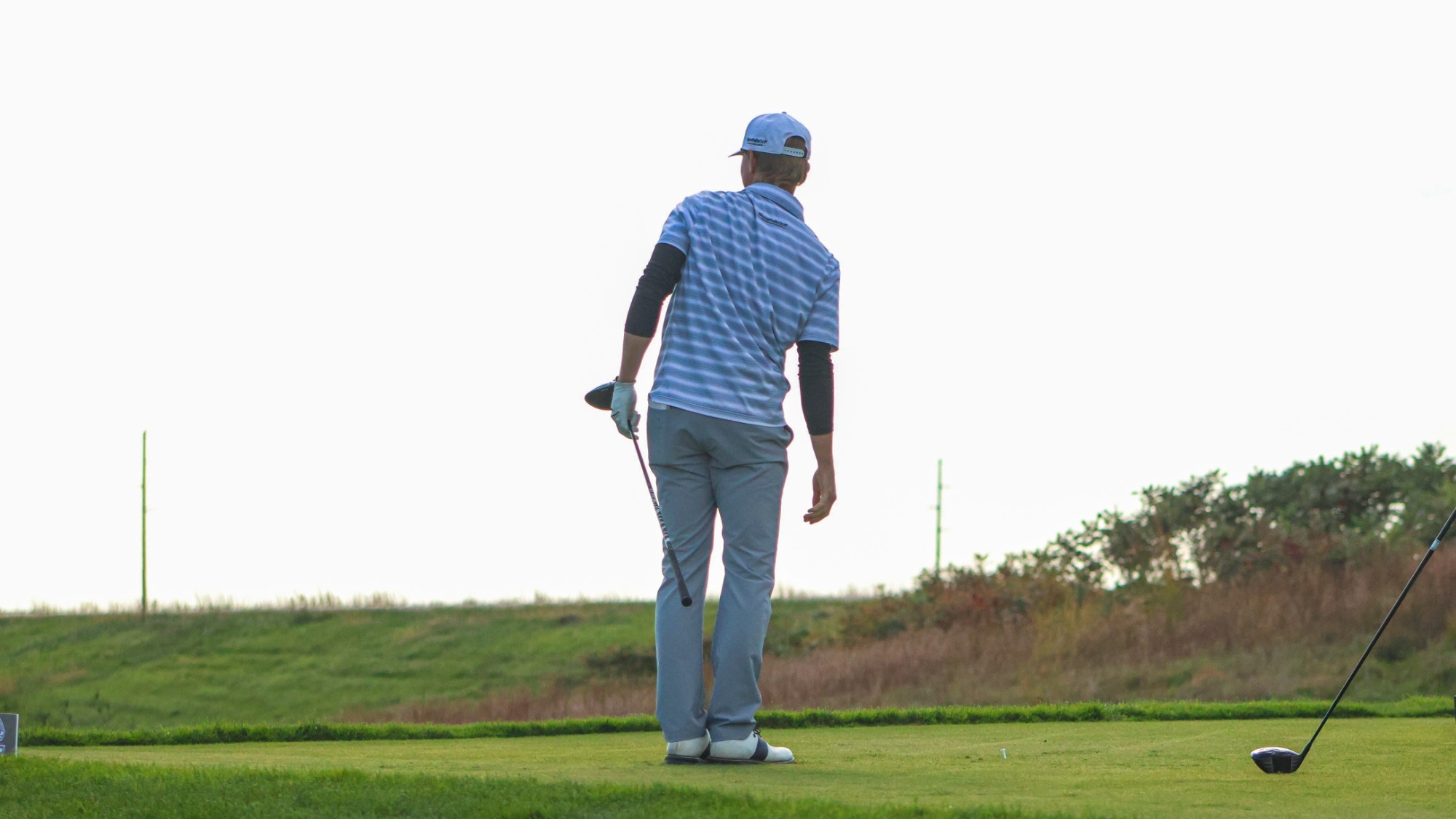 Men's Golfer watching shot after hitting ball